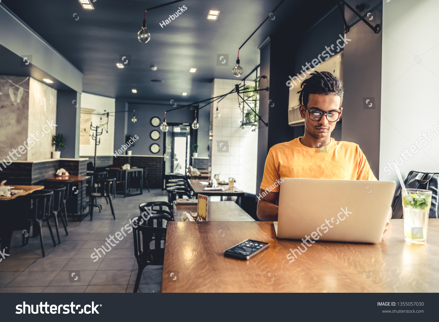 Handsome and successful indian man freelancer work laptop in cafe. Freelance and remote work. #1355057030