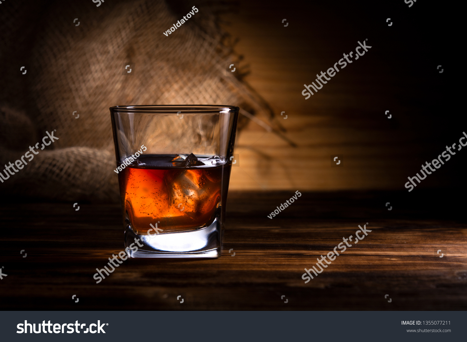 glass of whiskey or cognac on a wooden background #1355077211