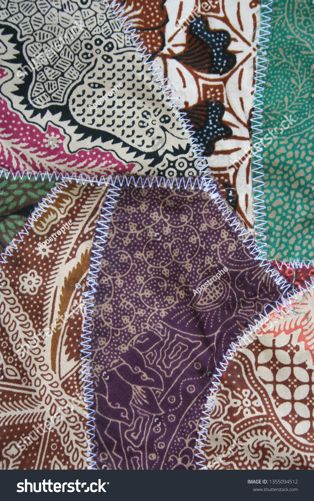 Batik material background, Indonesian material pieced together with white zigzag stiches in crazy quilt design in colorful blue green pink and brown colors #1355094512