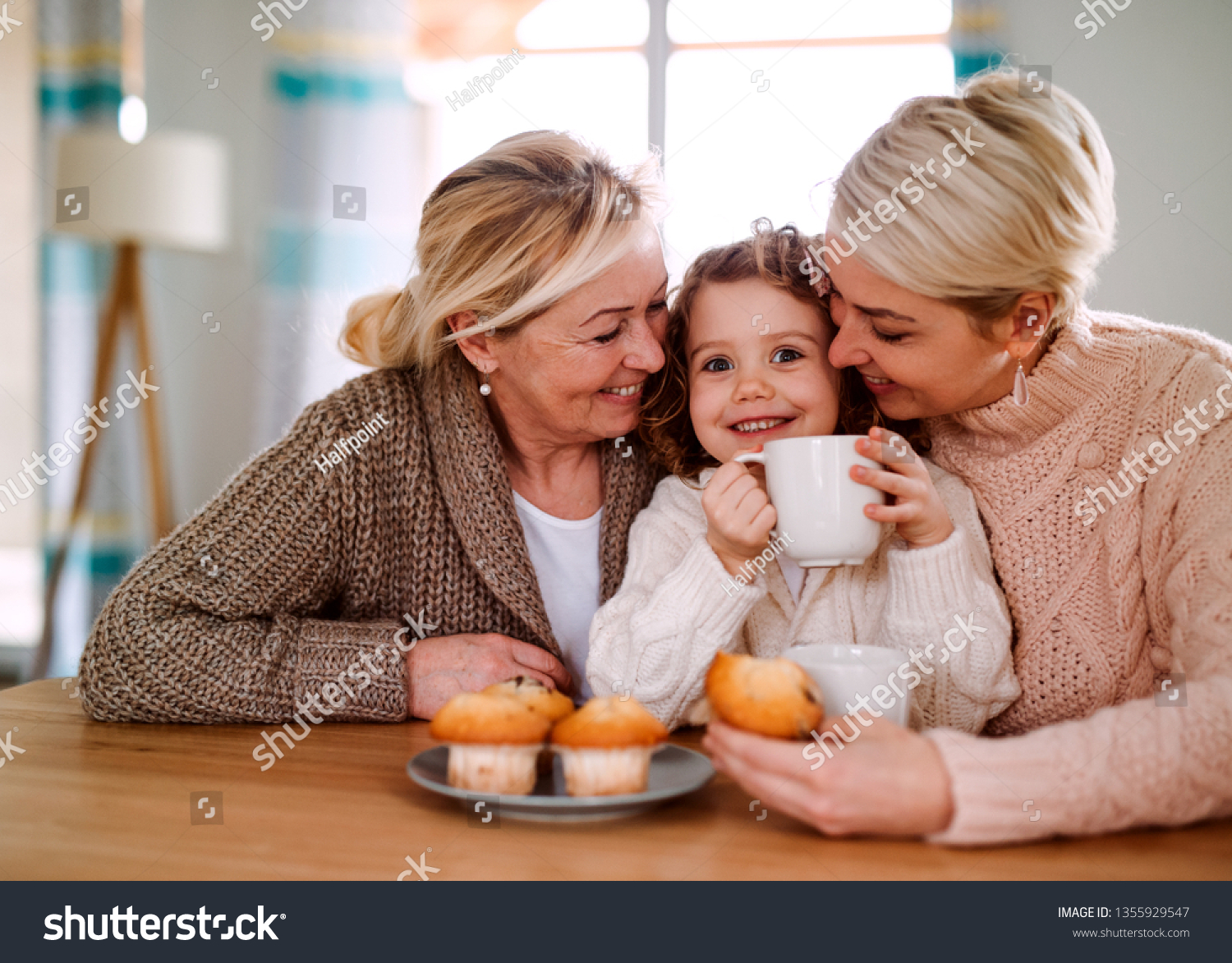 A portrait of small girl with mother and grandmother at the table at home. #1355929547