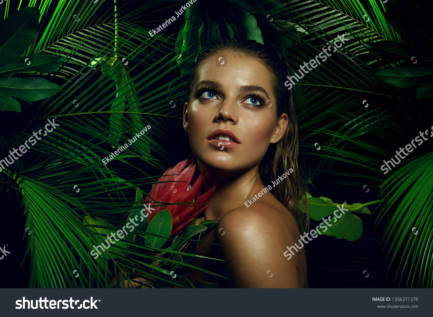 A beautiful tanned girl with natural make-up and wet hair stands in the jungle among exotic plants.fashion, beauty, makeup, cosmetics, beauty salon, style, personal care, posture, hair, hair. #1356371378