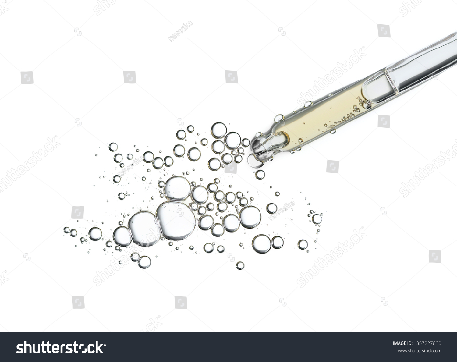 Serum oil in pipette isolated on white background. Cosmetic liquid dropper pipet with bubbles top view. #1357227830