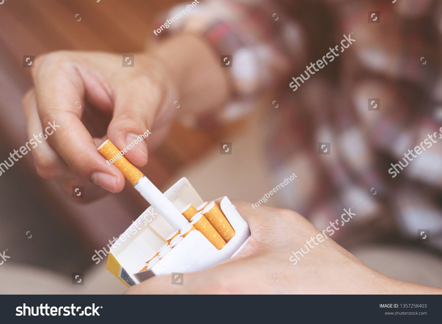 close up man hand holding peel it off cigarette pack prepare smoking a cigarette. Packing line up. photo filters Natural light. #1357258403