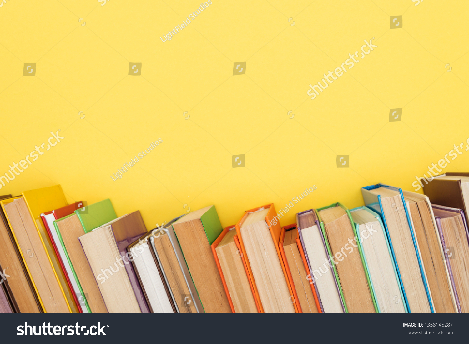 Bright colorful books with dark pages isolated on yellow #1358145287