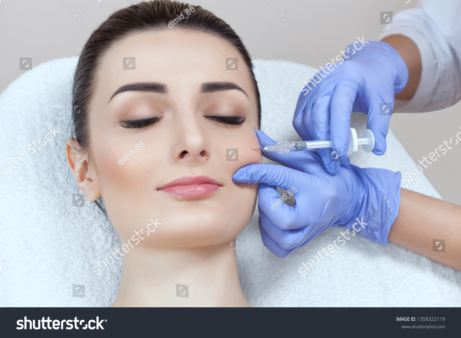 The doctor cosmetologist makes the Rejuvenating facial injections procedure for tightening and smoothing wrinkles on the face skin of a beautiful, young woman in a beauty salon.Cosmetology skin care. #1358322119