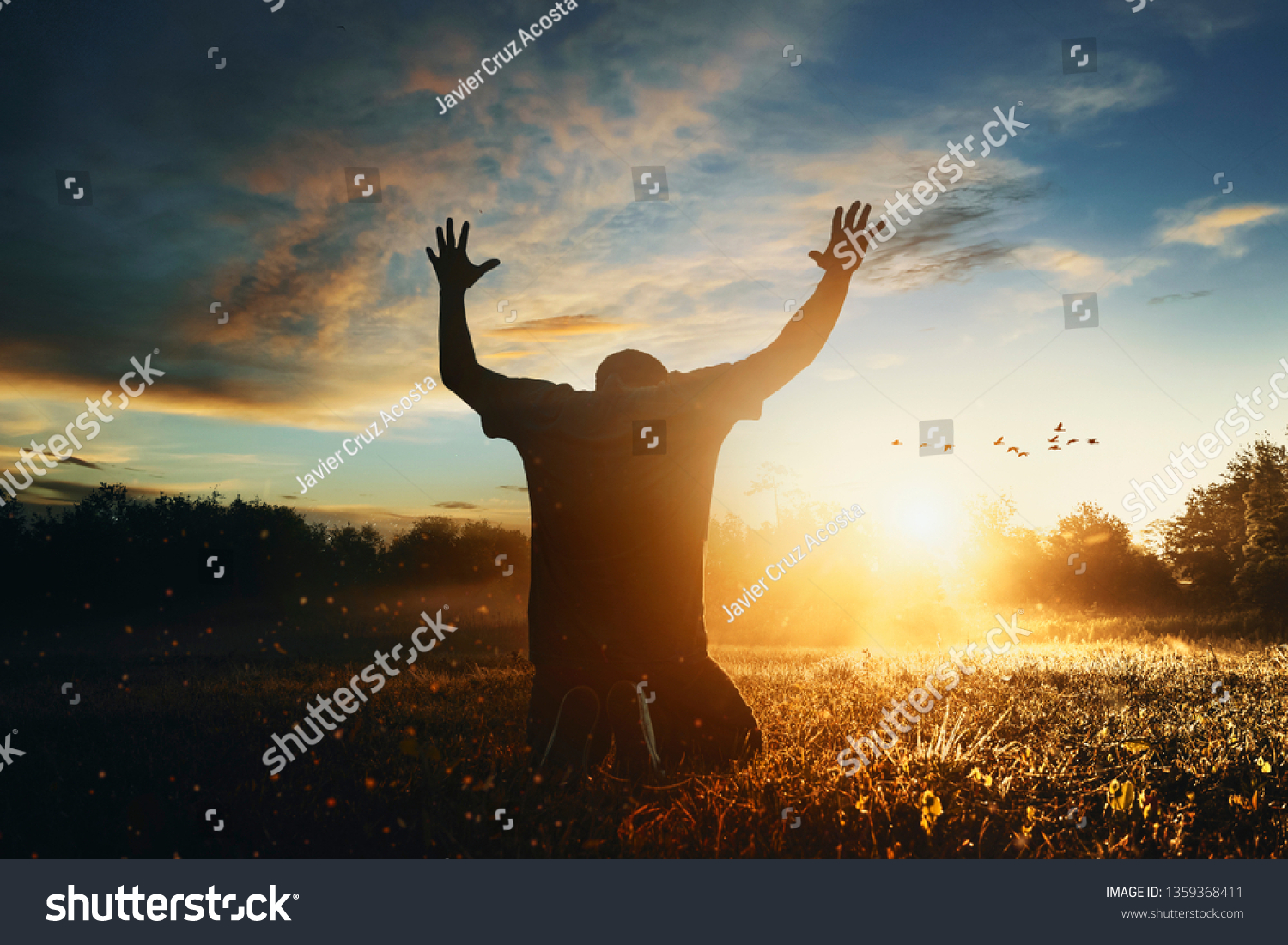 Grateful man man raising his hands in worship in the countryside. #1359368411