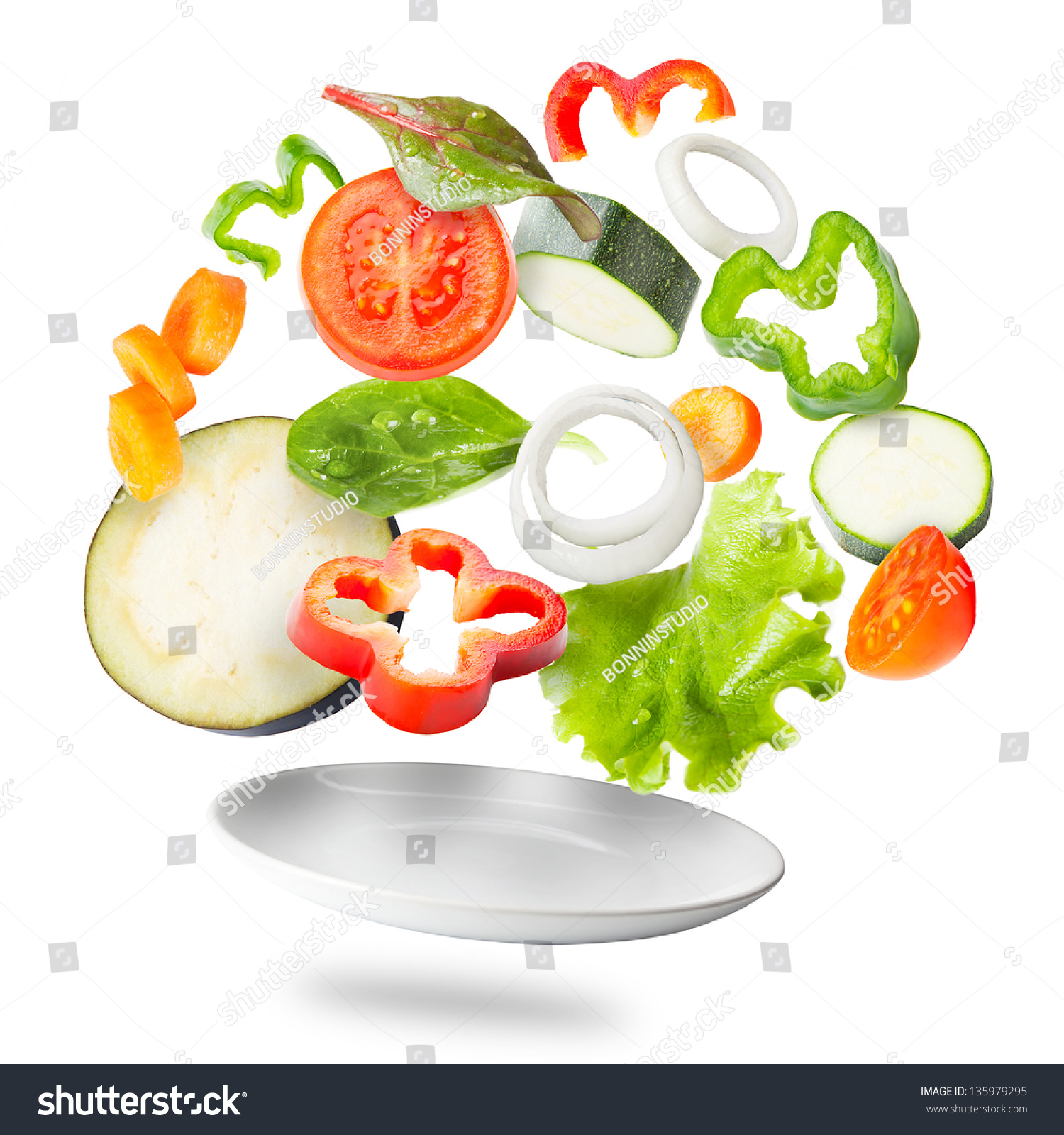 Assorted fresh vegetables flying in a plate / Light salad with flying fresh vegetables #135979295