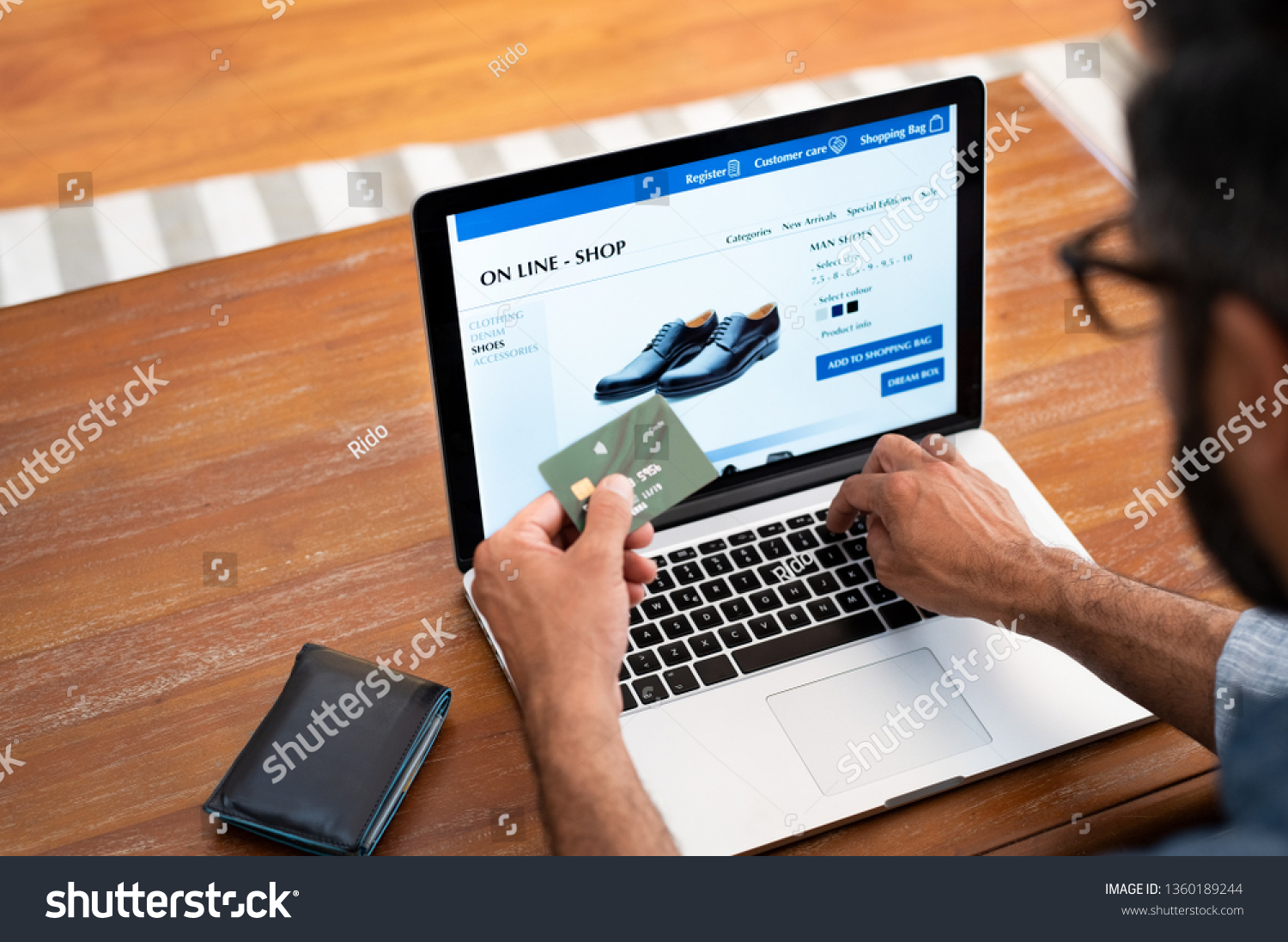 Man using credit card to do shopping online with laptop. Mature man buying formal shoes online. Man making online payment with credit card and laptop. #1360189244