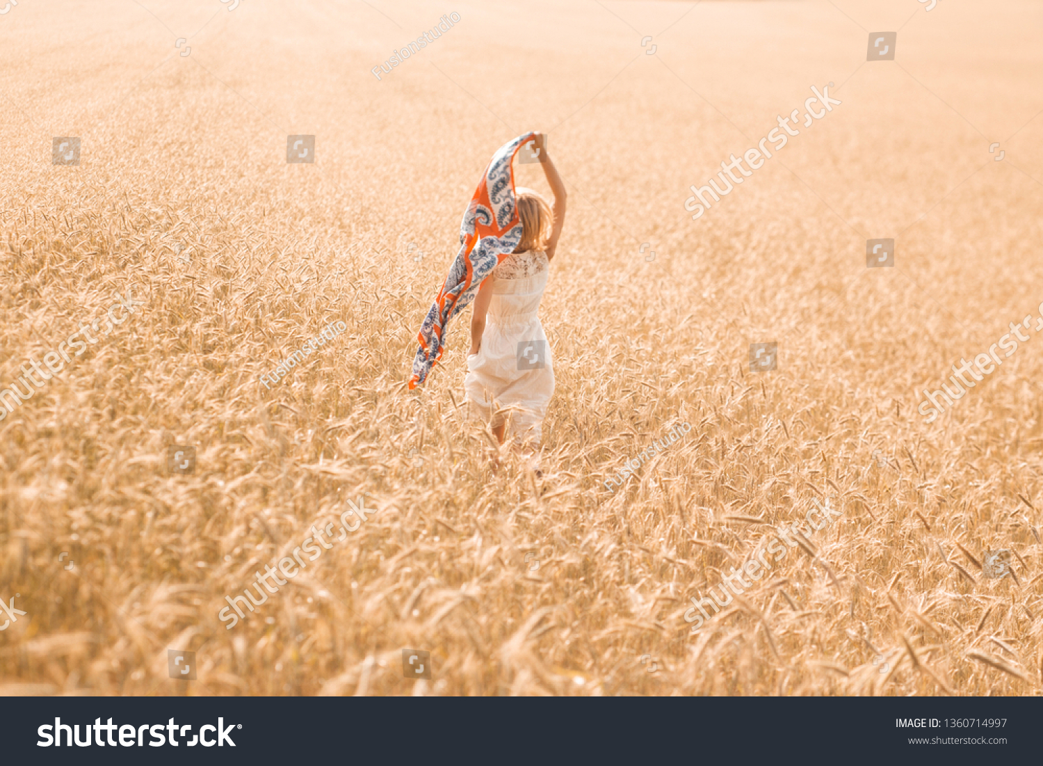 Blonde girl model on a wheat field. Young woman enjoying nature. Beautiful girl running in the rays of sunlight. Sunlight. #1360714997