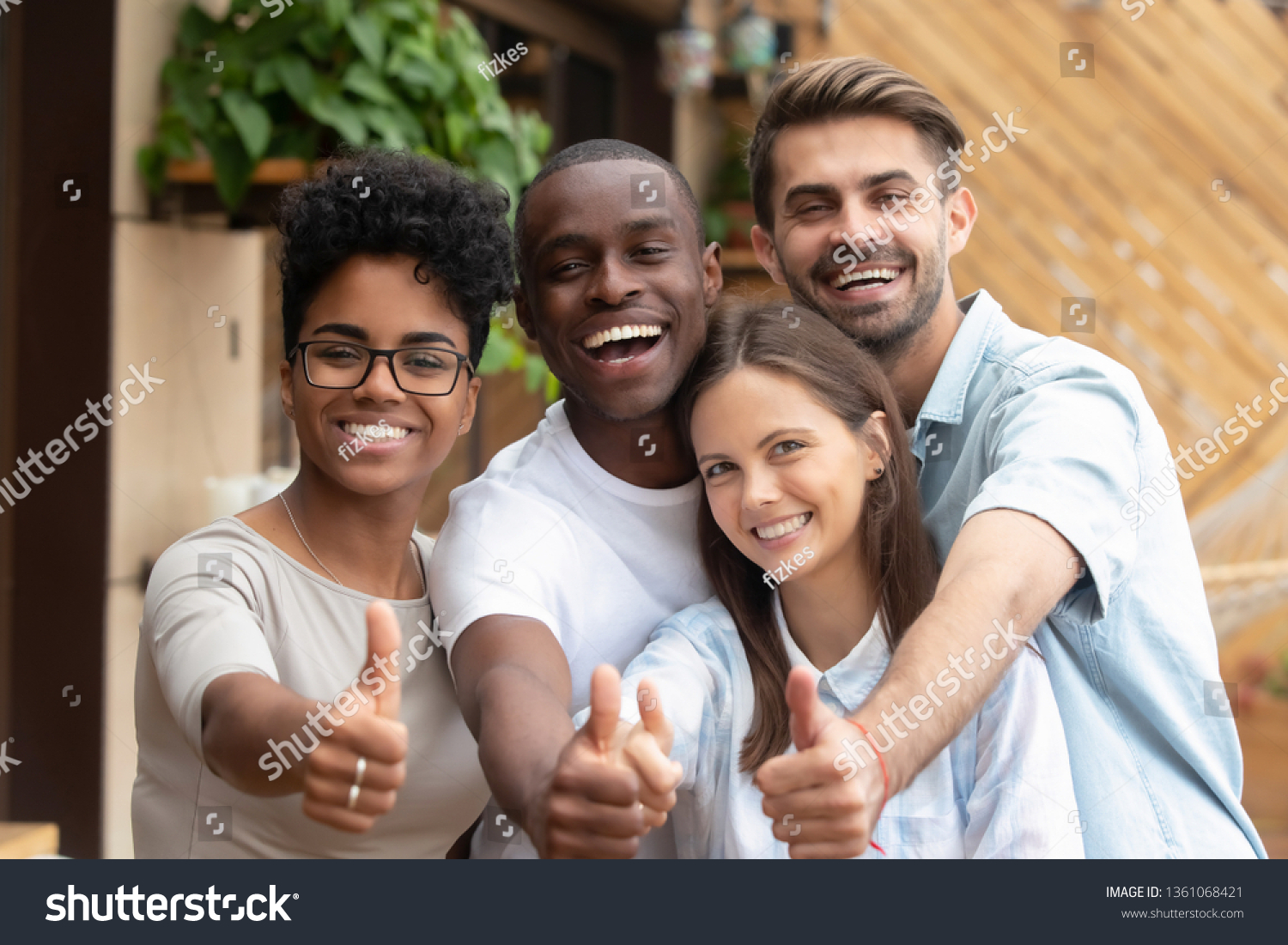 Happy multi ethnic friends group showing thumbs up, smiling diverse young people looking at camera with like gesture recommend good quality racial diversity equality, multiracial friendship, portrait #1361068421