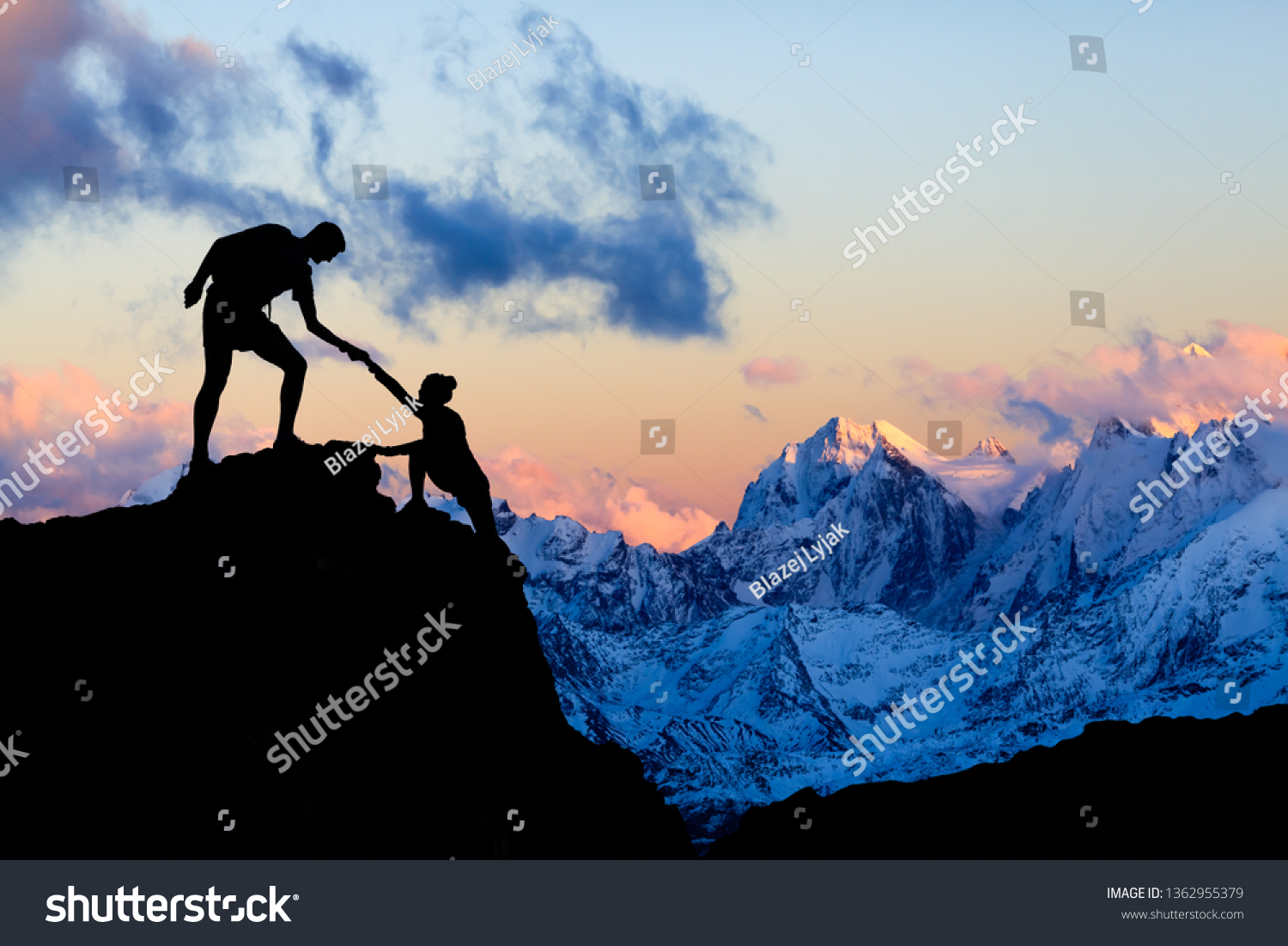 Teamwork couple helping hand, trust in mountains. Team of climbers man and woman hiking, help each other on top of mountain, climbing together, inspiring sunset on Elbrus, Russia. #1362955379