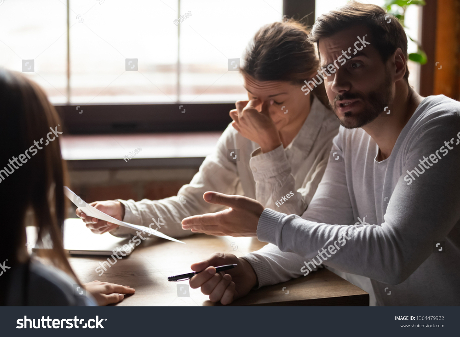 Diverse millennial people sitting at table in office indignant man accusing incompetent unqualified woman colleague pointing on financial report with mistakes, lack of education and knowledge concept #1364479922