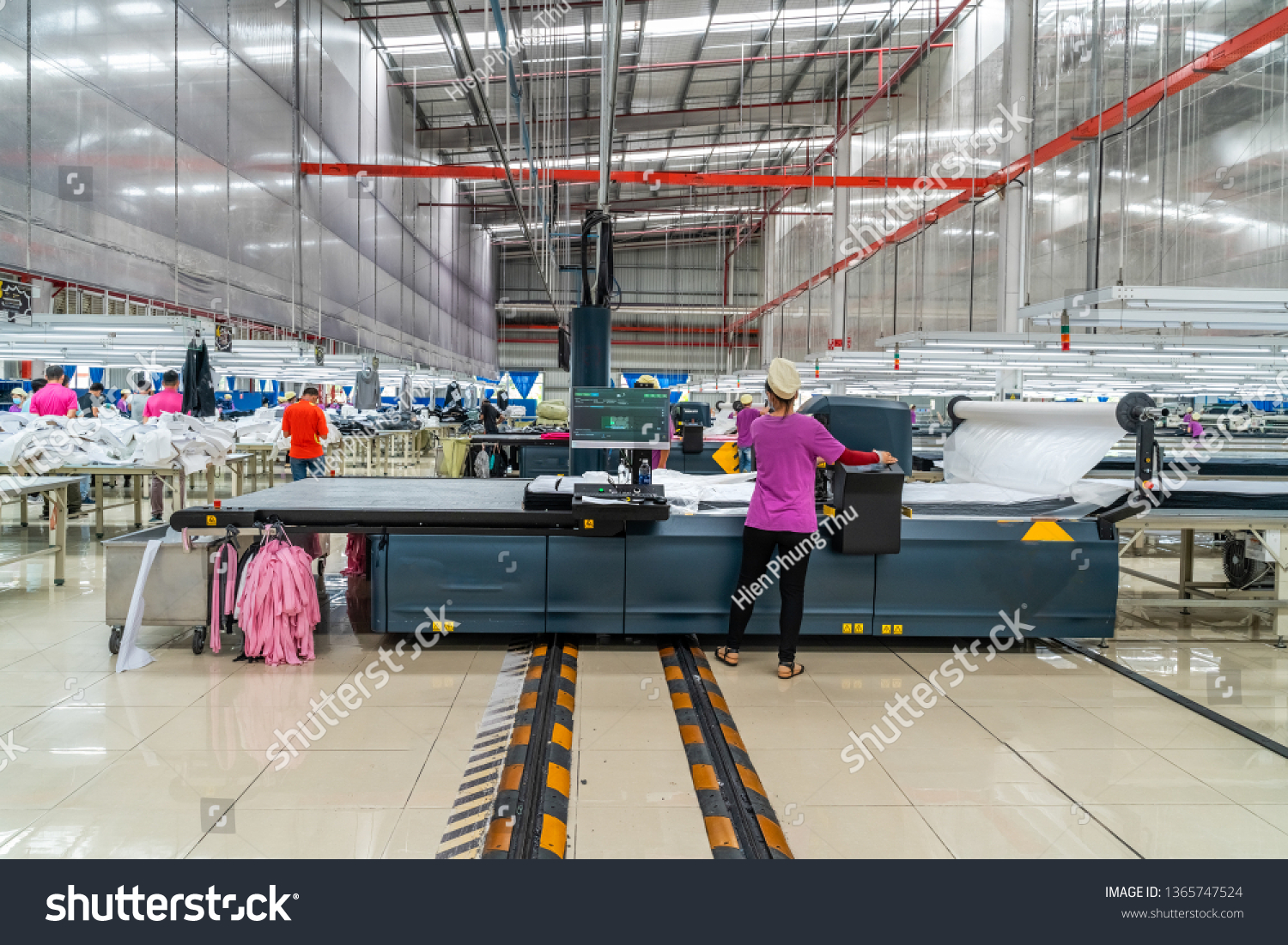 Industrial cloth cutting machine and fabric cutting area in garment factory in industrial zone in Ho Chi Minh City, Vietnam, with modern machinery and technology systems. #1365747524