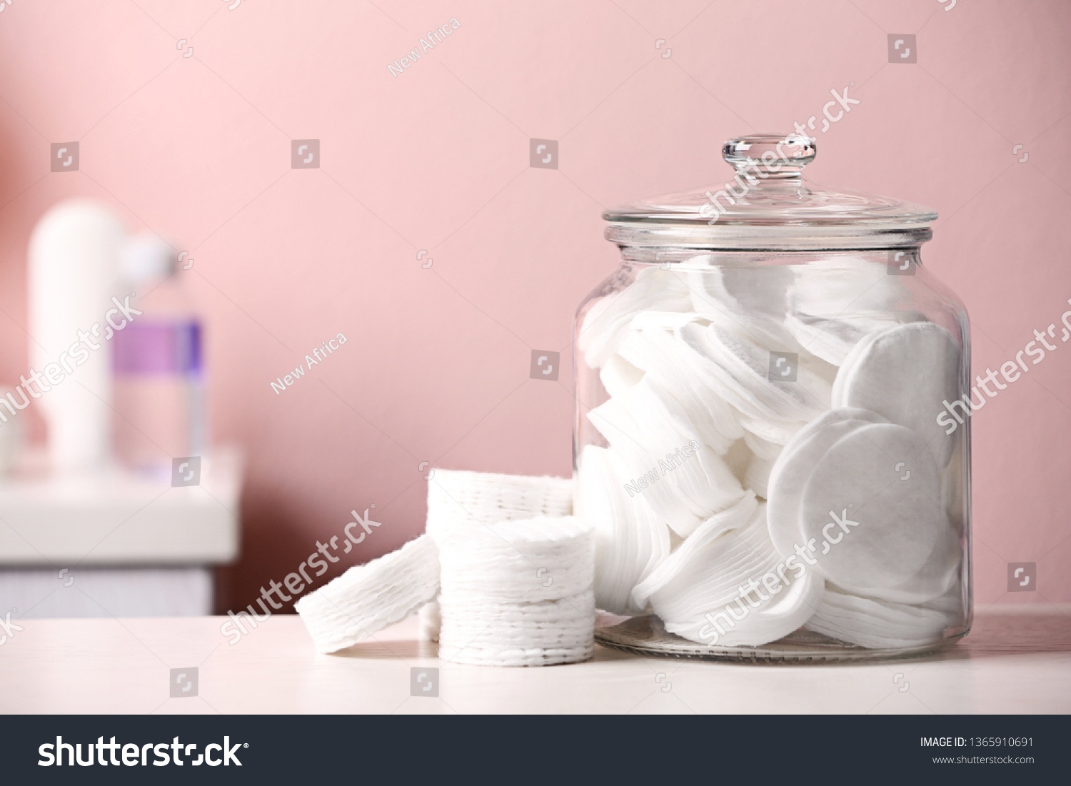 Glass jar with cotton pads on table in bathroom, space for text #1365910691