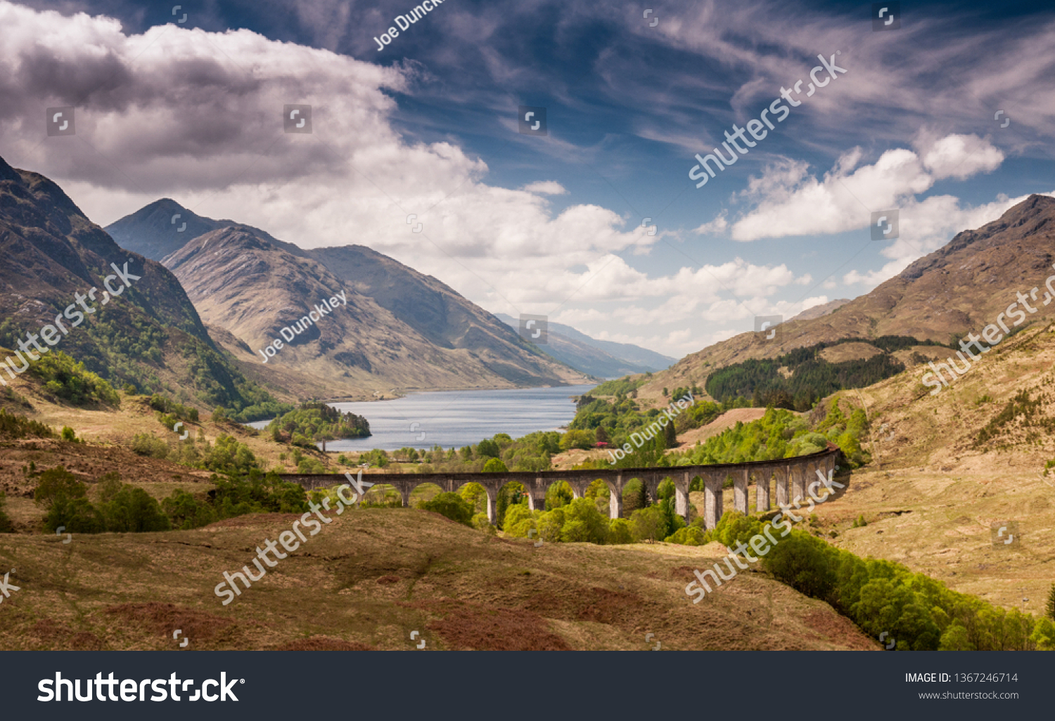 The Glenfinnan Viaduct carries the West Highland Railway Line high above Glen Finnan valley beside the lochs and mountains of Scotland. #1367246714