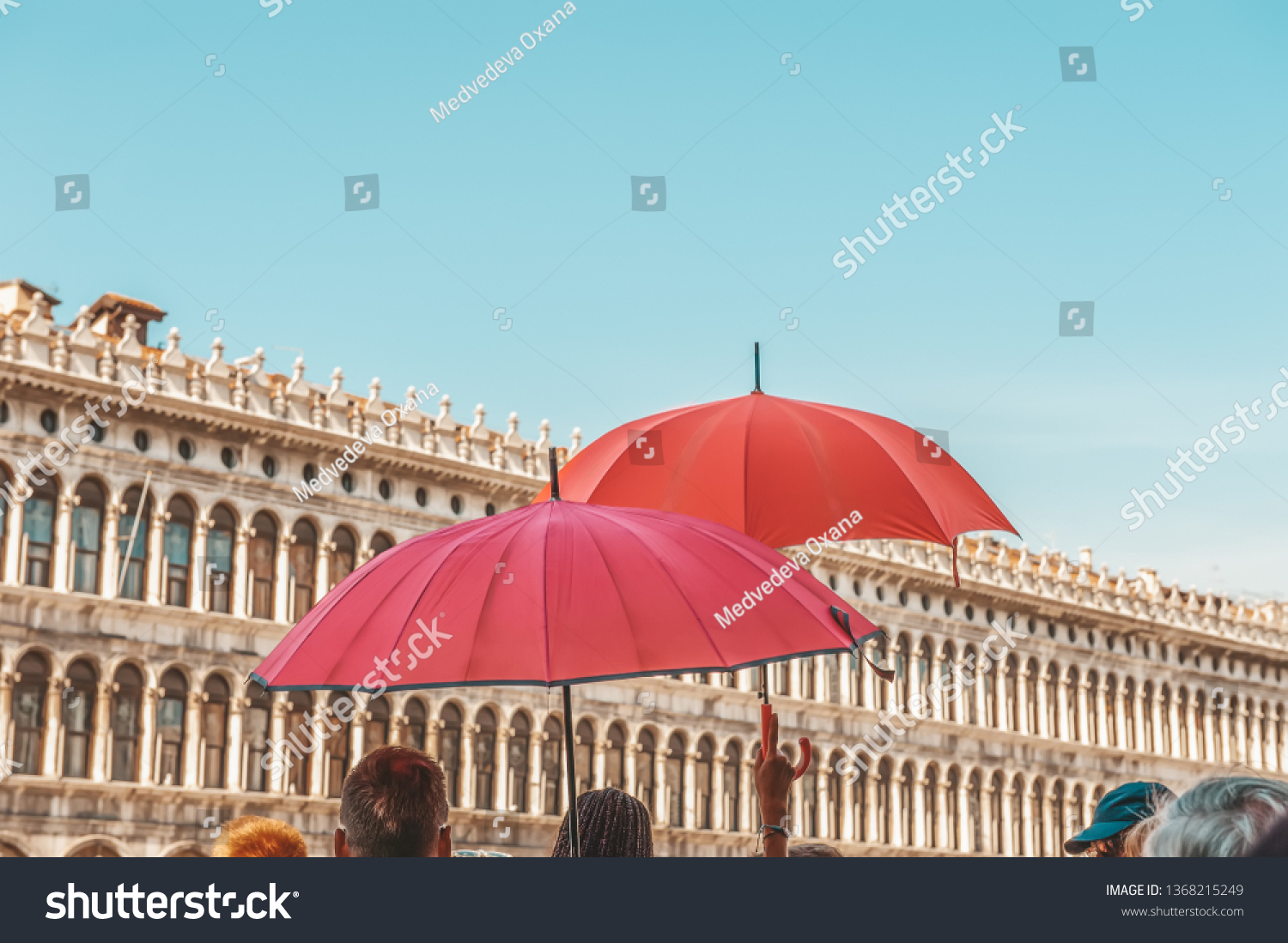 Red umbrellas of tour guides conducting tours on the background of the Piazza San Marco in Venice. Tourist destination. #1368215249