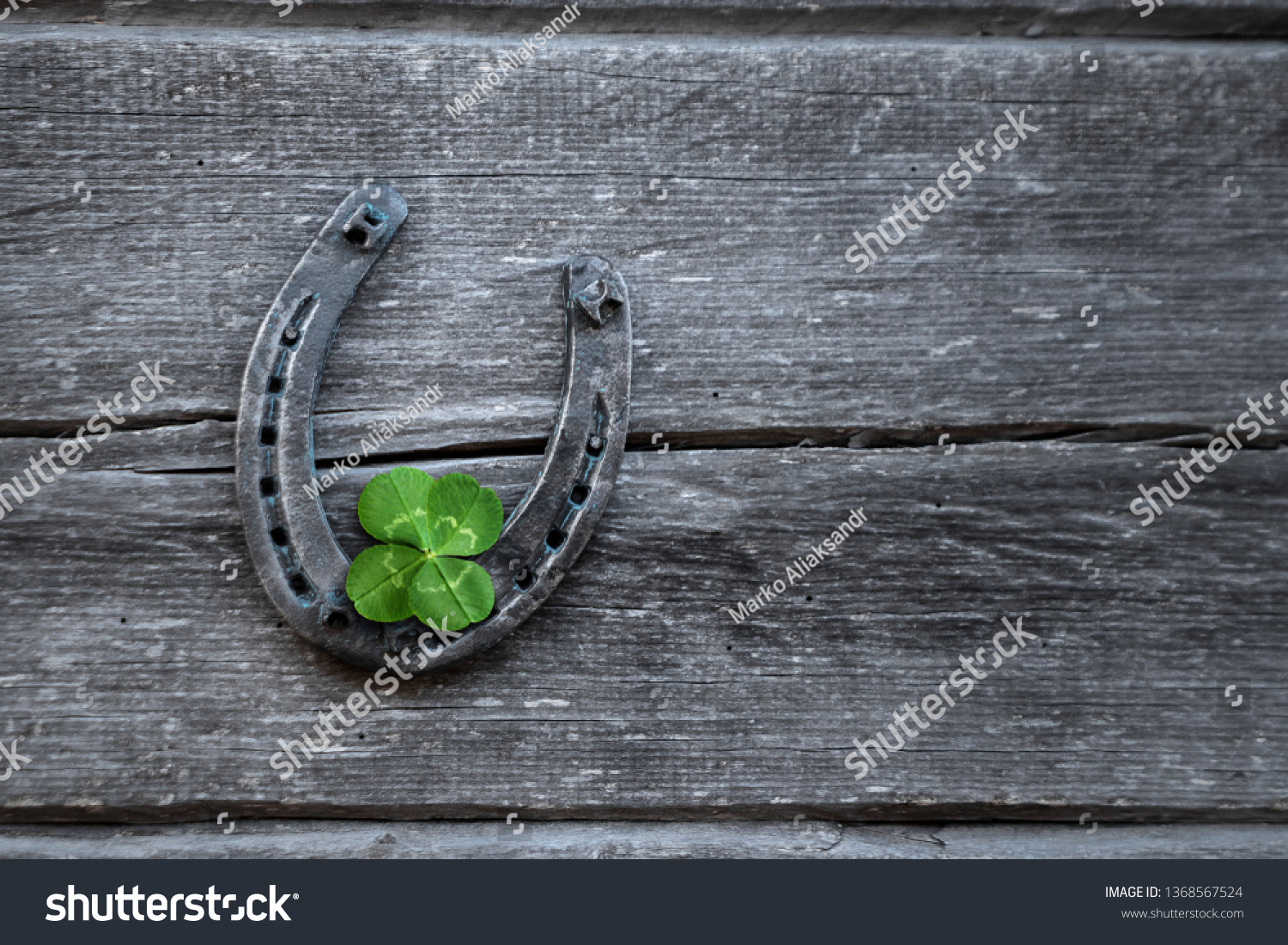 Old horseshoe and four leaf clover on a vintage wooden board. The concept of luck, luck, luck. St. Patricks Day card. #1368567524