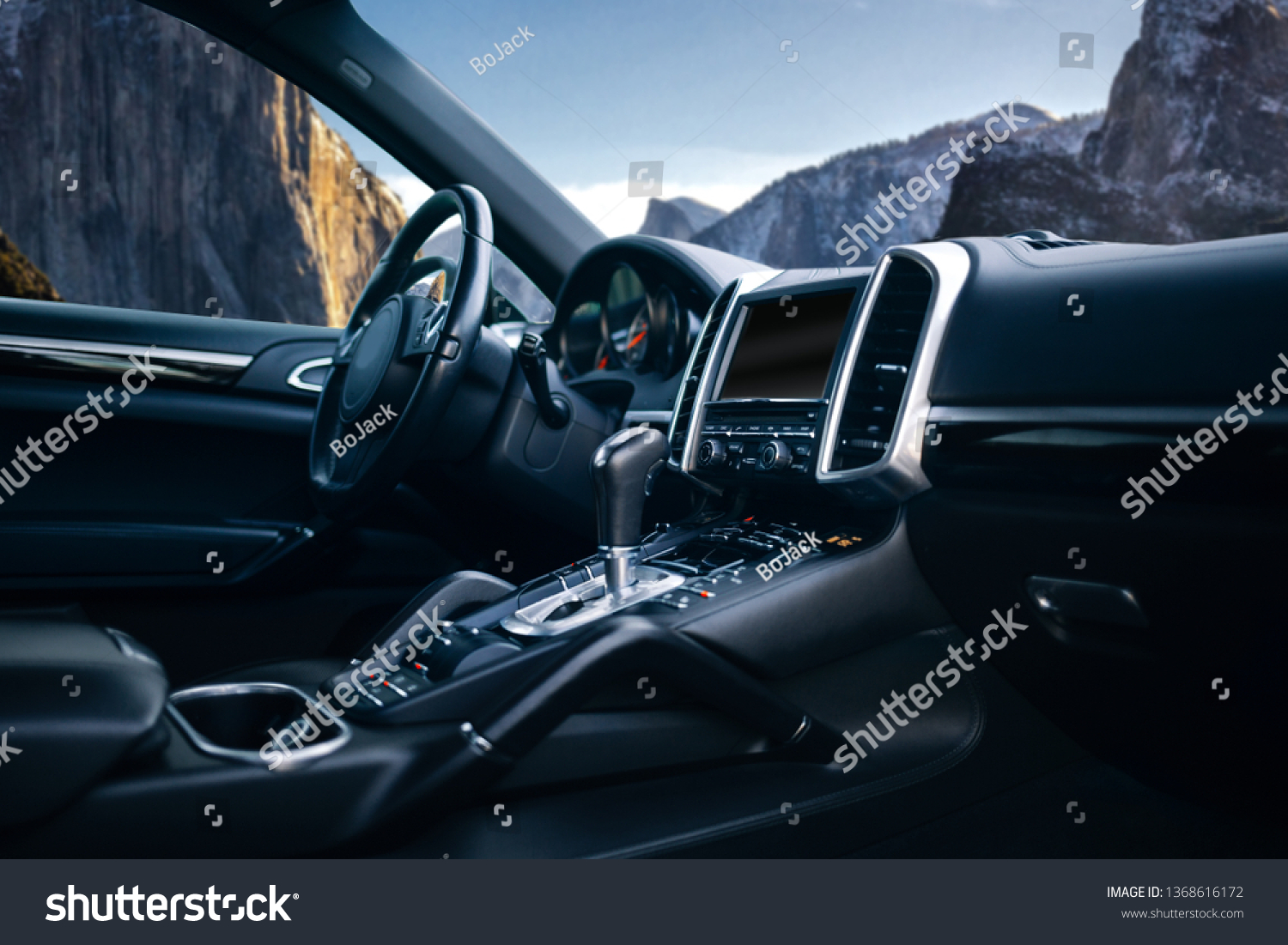 Expensive suv car interior with the steering wheel, multimedia dashboard, and gearbox handle #1368616172
