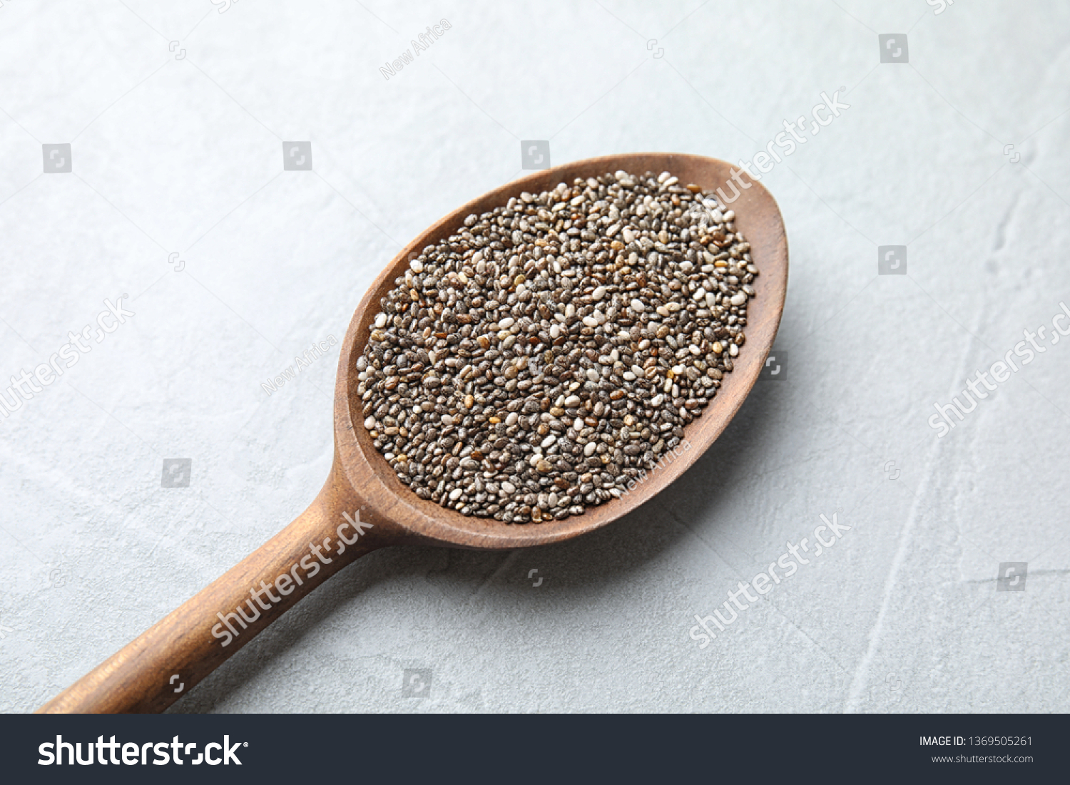 Spoon with chia seeds on light background, closeup #1369505261