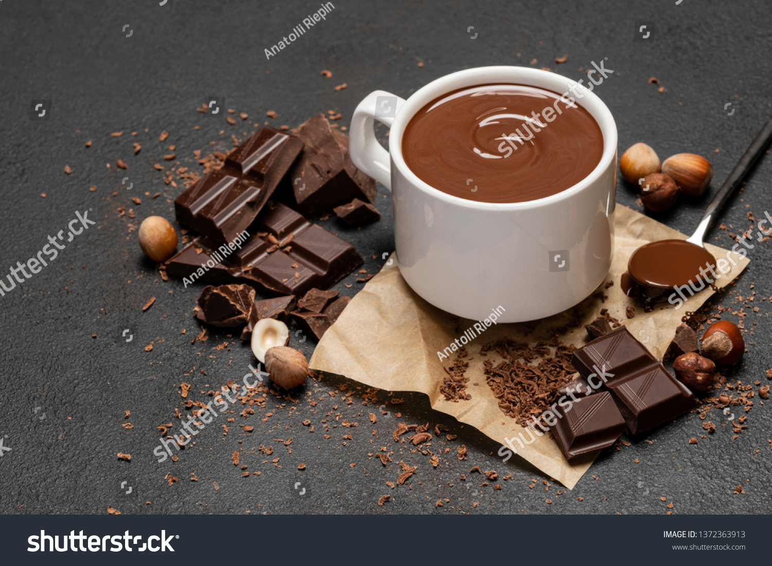 Cup of hot chocolate and pieces of chocolat on dark concrete background #1372363913