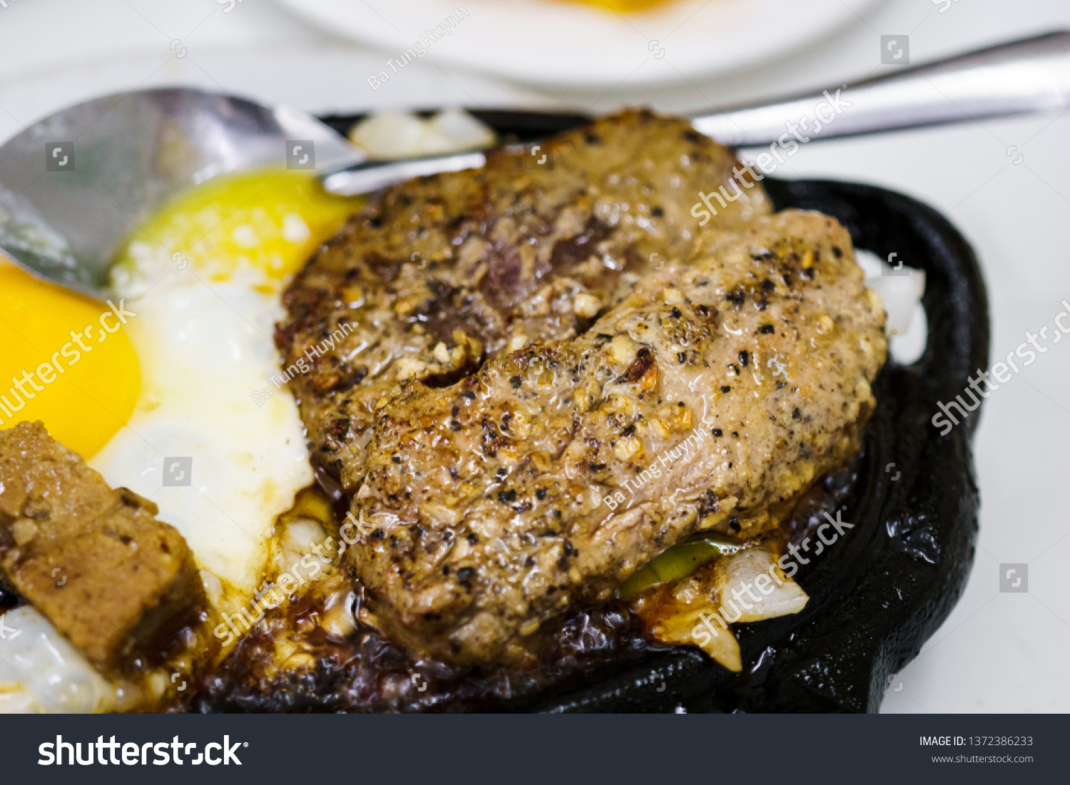 Beefsteak with egg and butter on cast iron #1372386233
