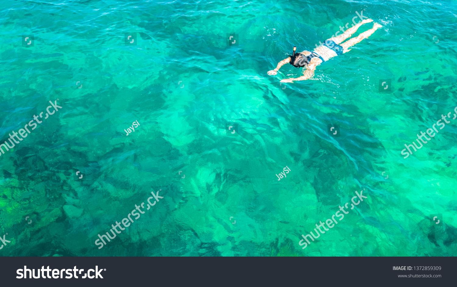 Aerial top view of woman snorkeling from above, girl snorkeler swimming in a clear tropical sea water with corals during summer vacation in Thailand #1372859309