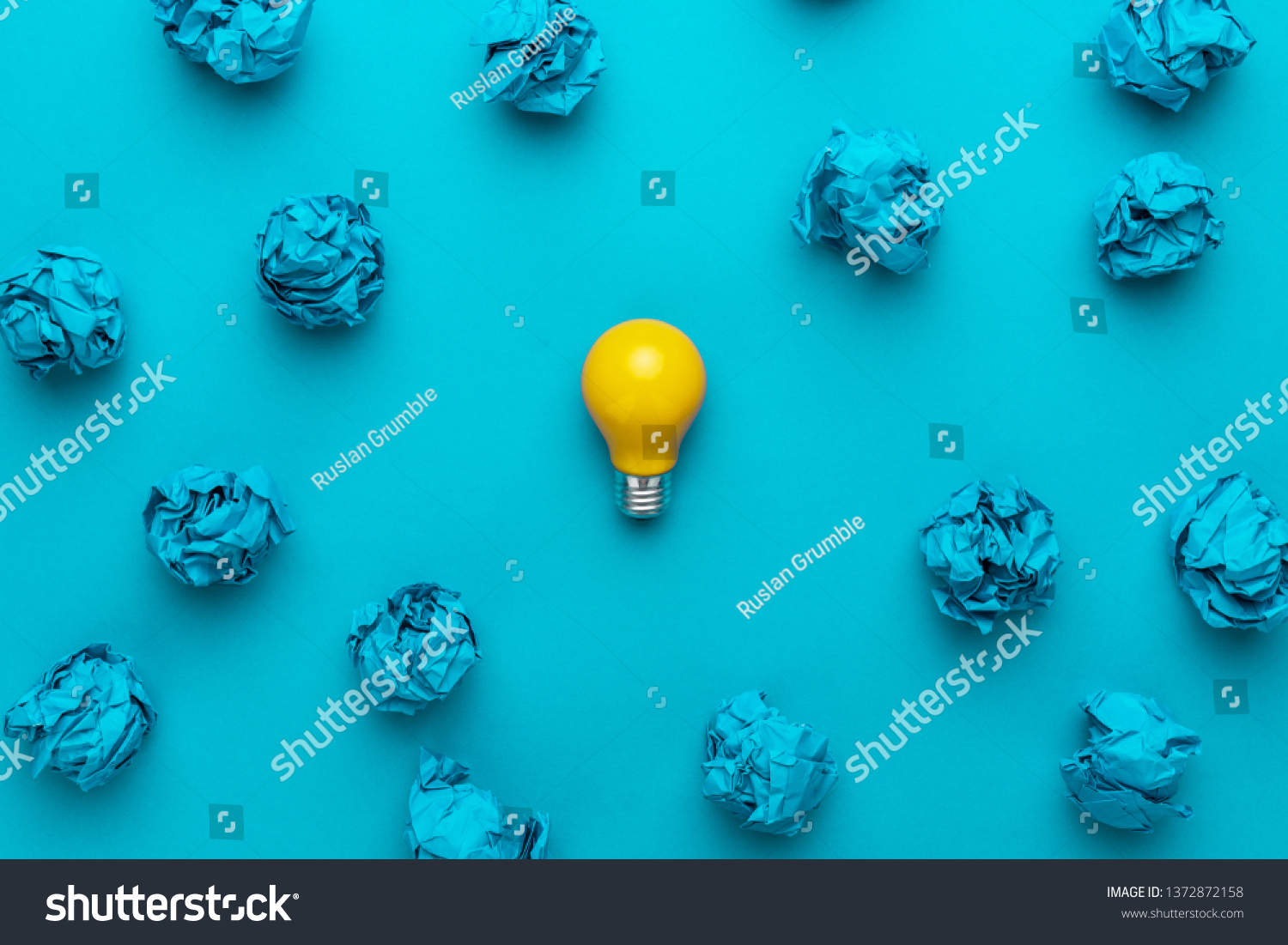 new idea concept with crumpled office paper and light bulb. top view of great business idea concept over blue background. creative solution during brainstorming session concept #1372872158