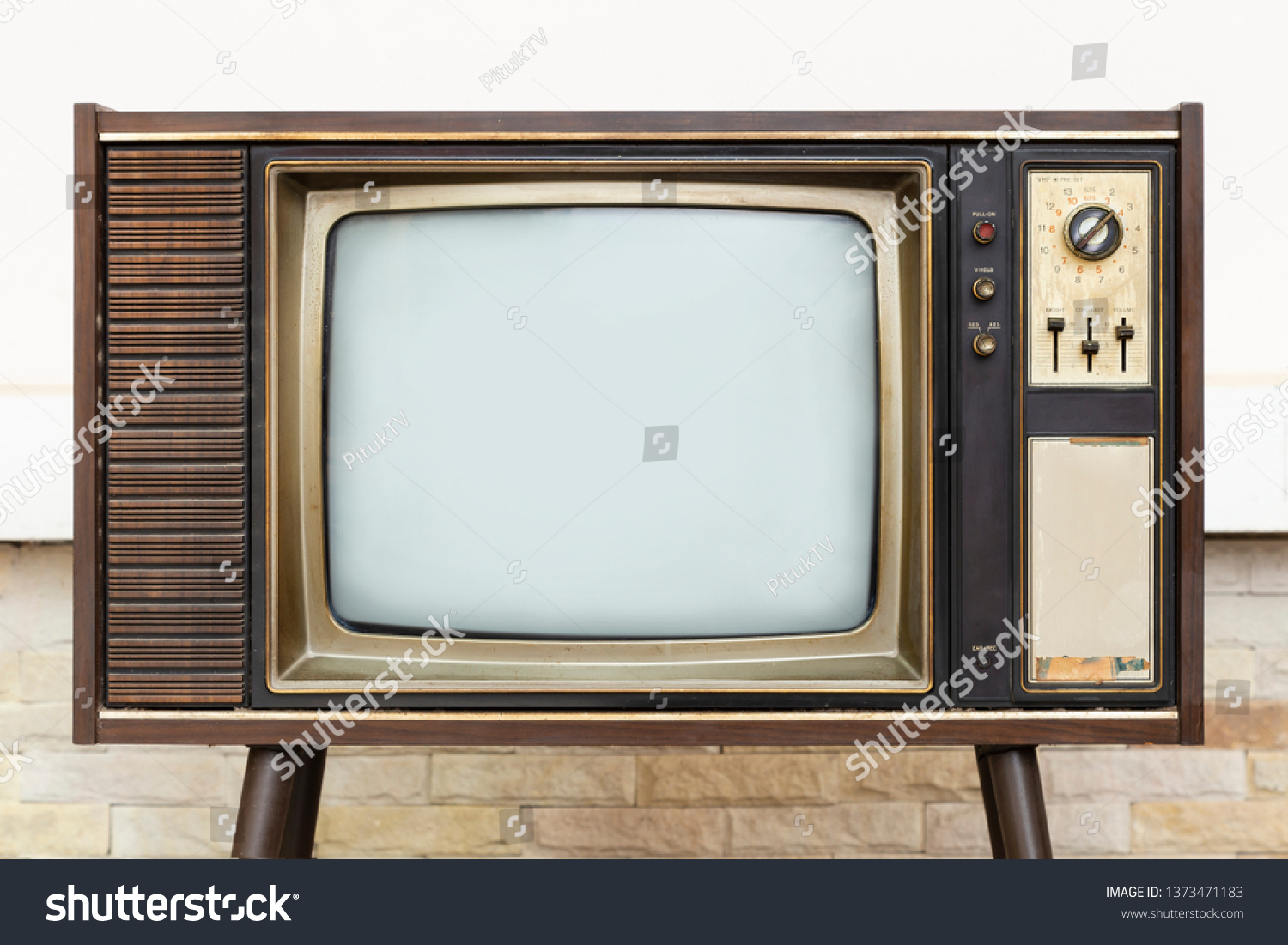 Retro, old television stands with brick wall background #1373471183