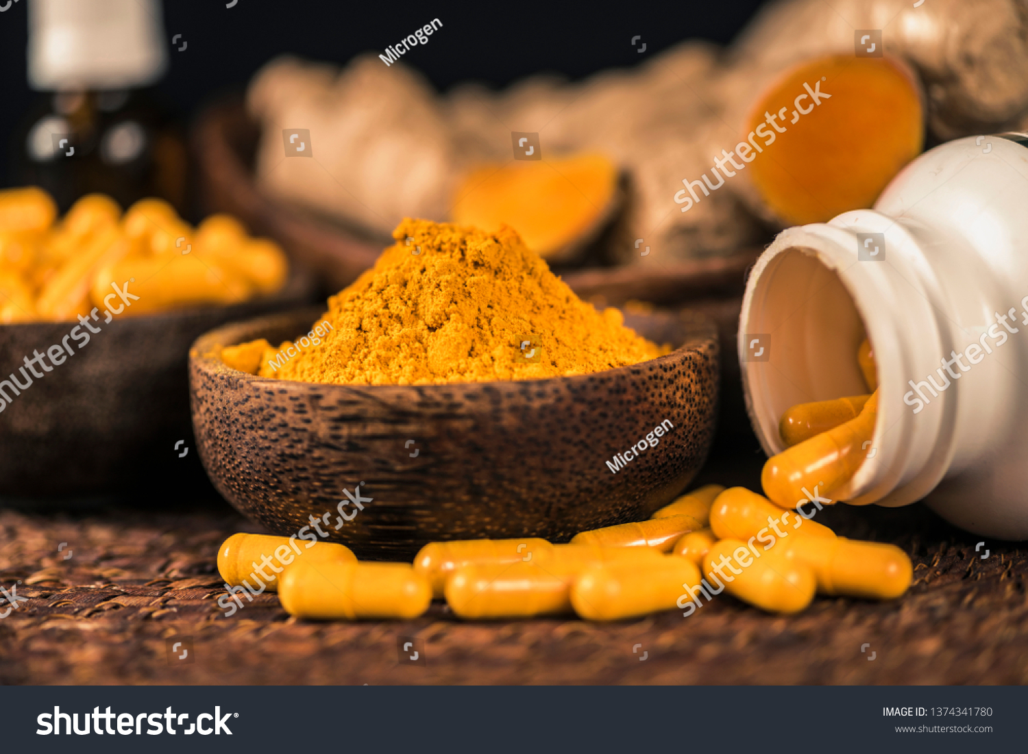 Curcumin supplement capsules, turmeric powder in glass bowl and curcuma root in background. Herbal medicine Curcuma against inflammation #1374341780