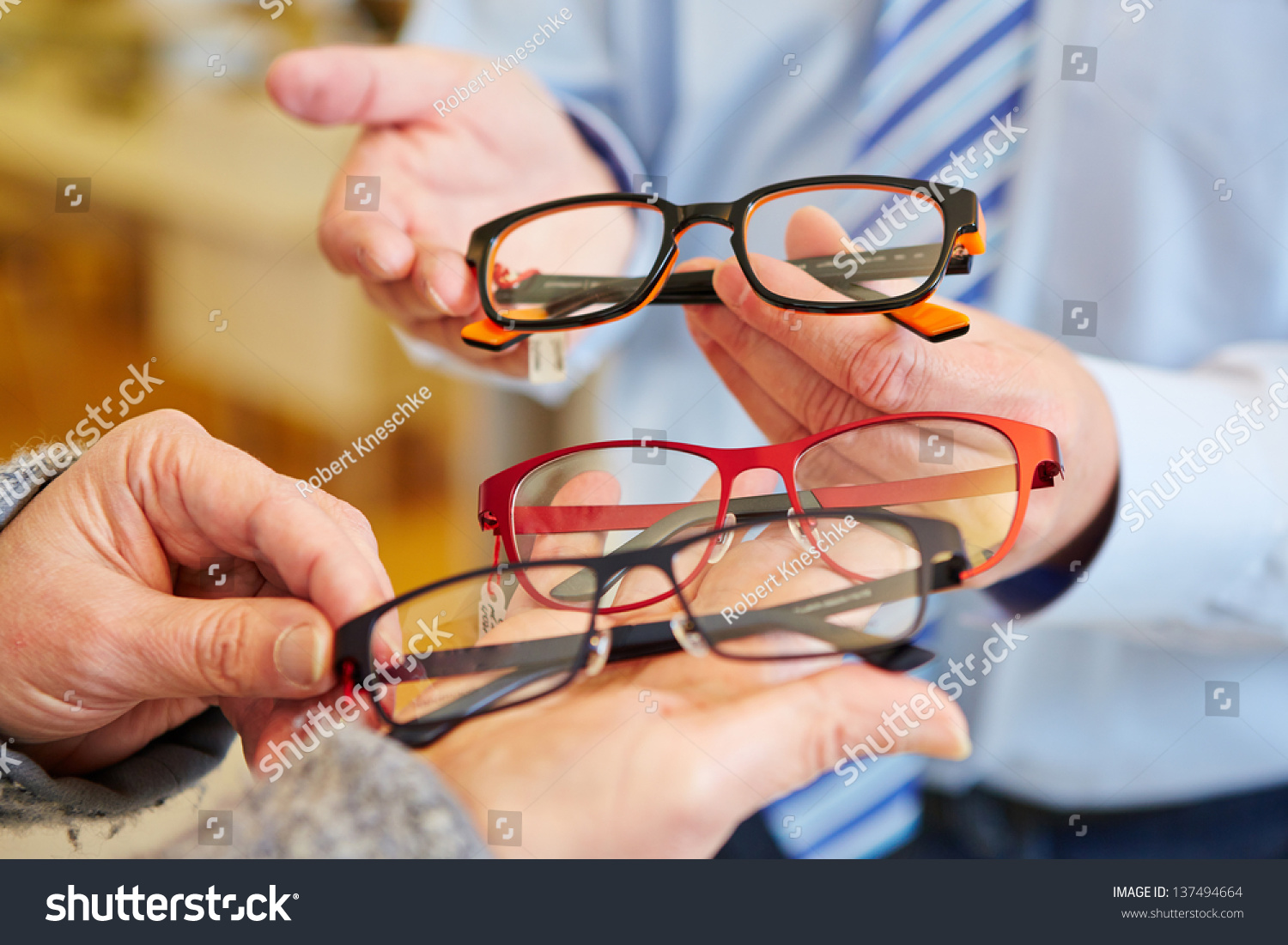 Optician offering a customer a choice of different glasses #137494664