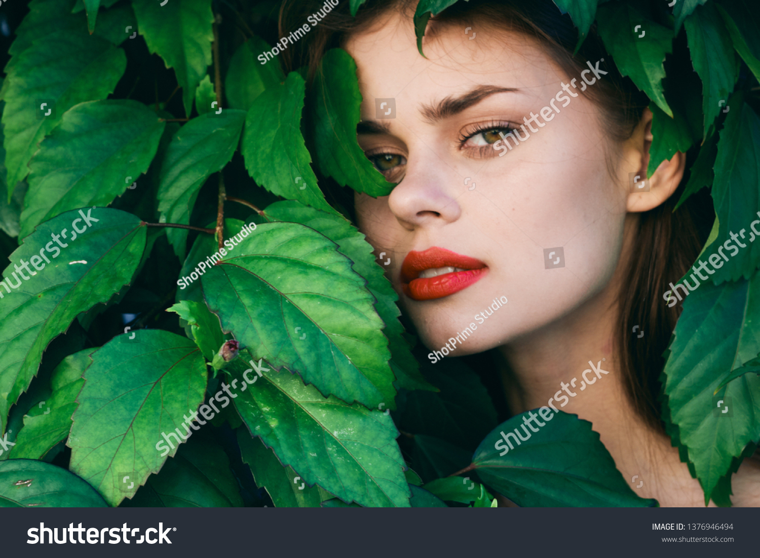 pretty woman with make up on face green shrub exotic nature #1376946494
