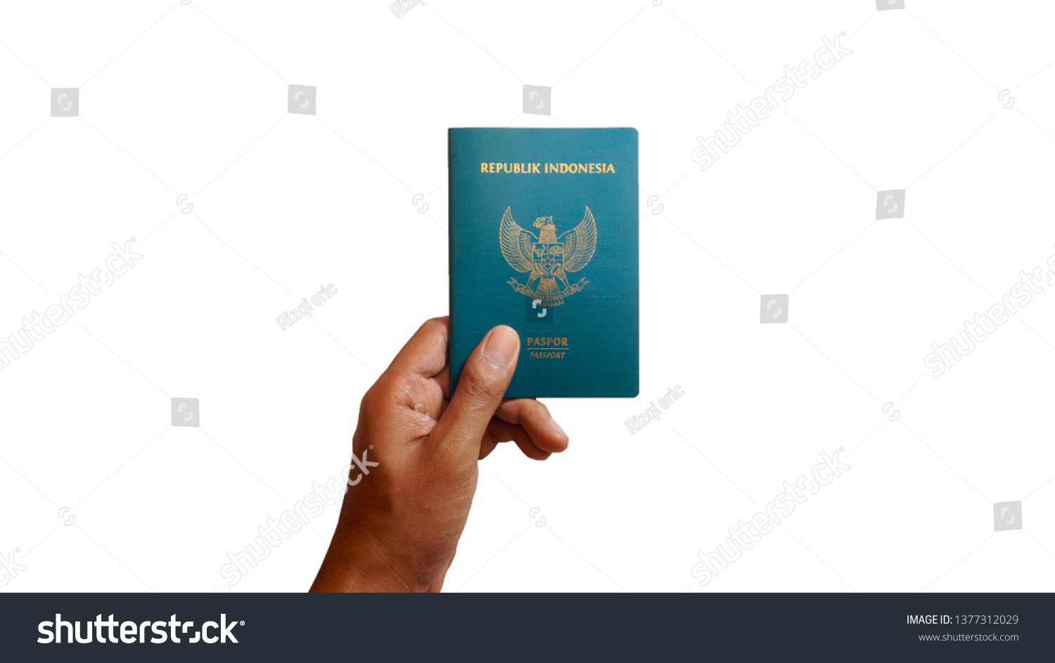 Close up hand holding indonesian passport isolated on white background - Image #1377312029