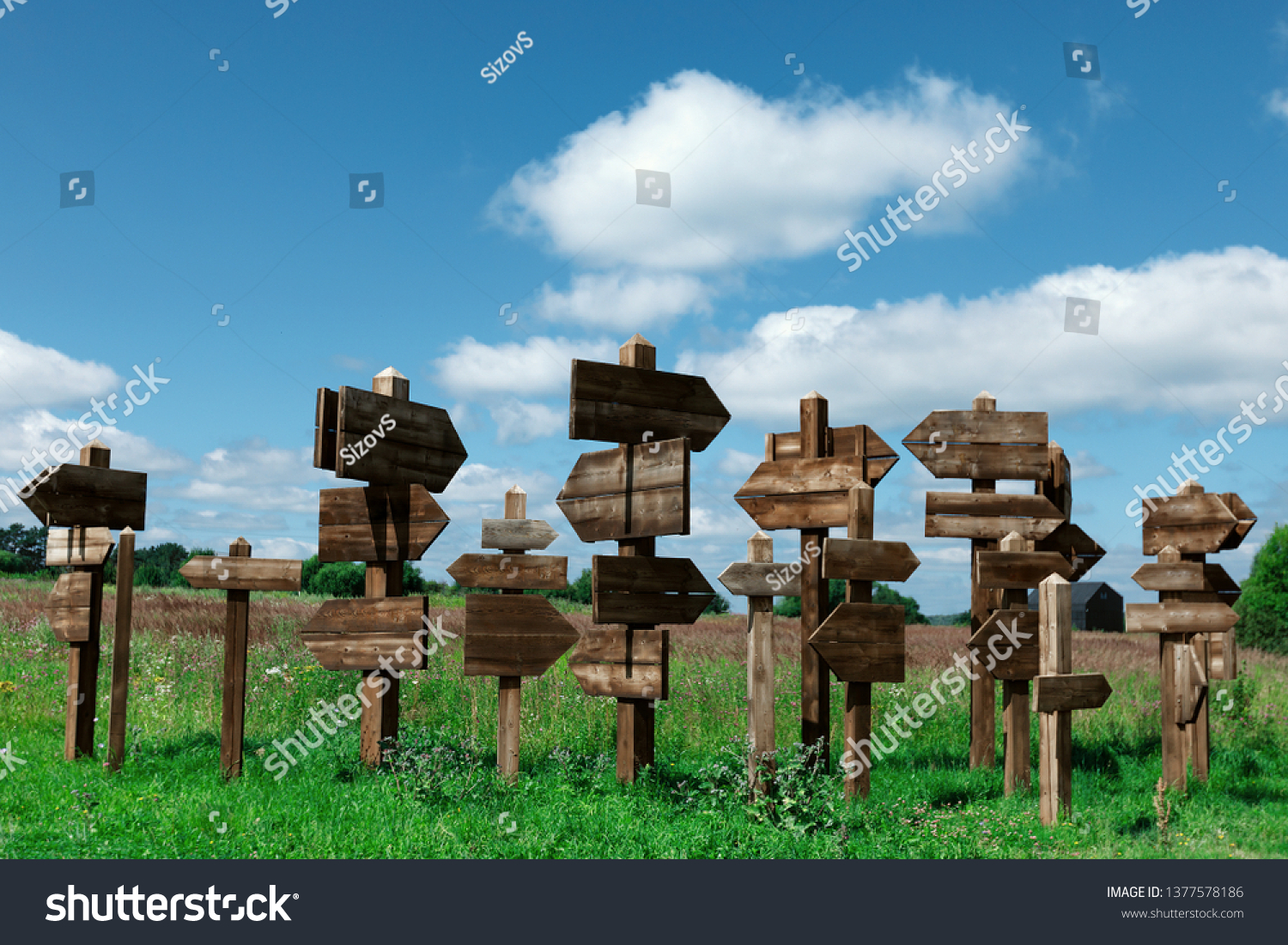 Wooden signs indicating the direction in different directions to different directions. background: cloudy sky. #1377578186