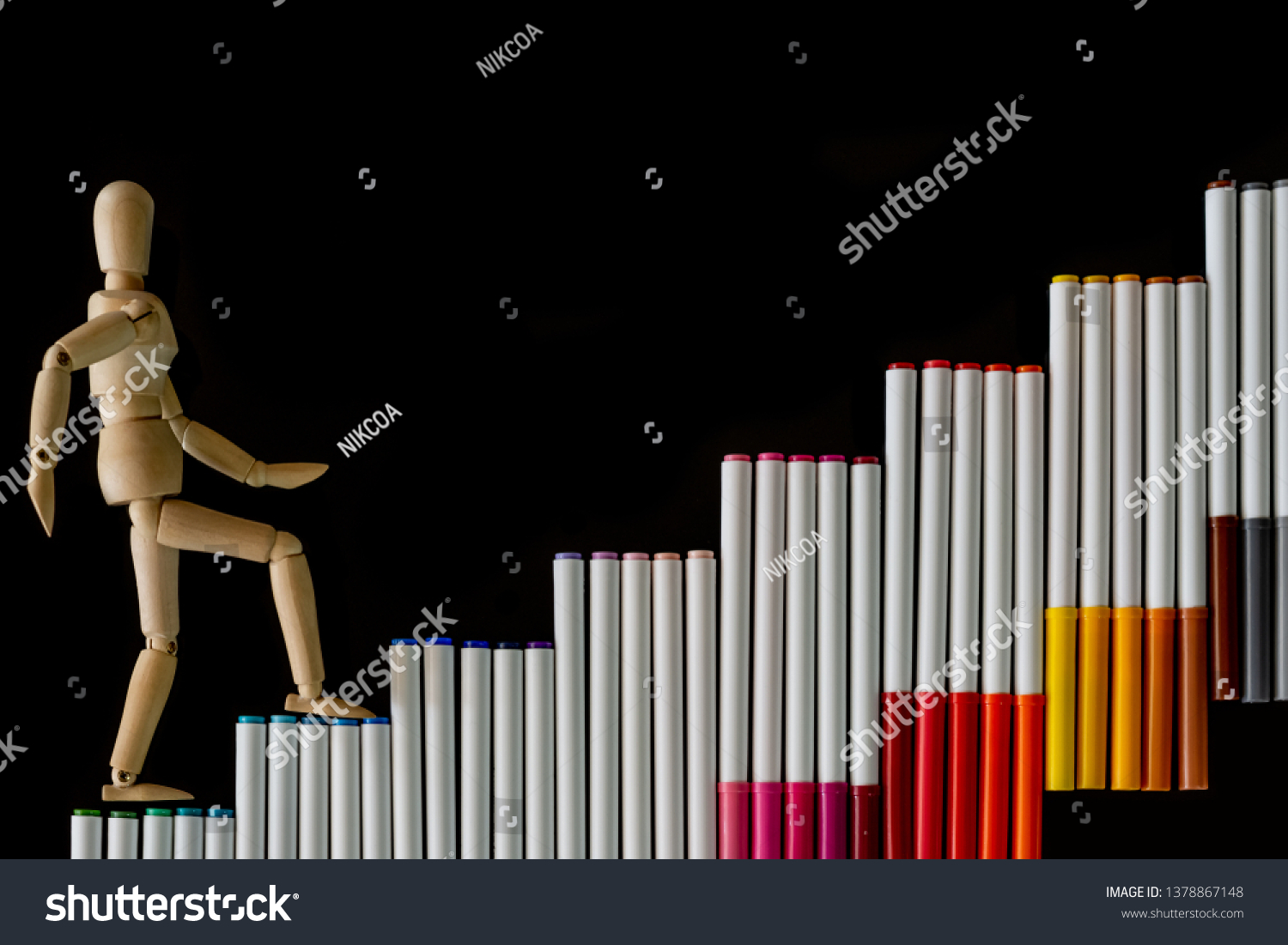 Ascending step stairs (by colorful marker pens)and wooden man model going upword isolated on dark background.Encourage motivation and inspiration to do something for success.Progression concept. #1378867148