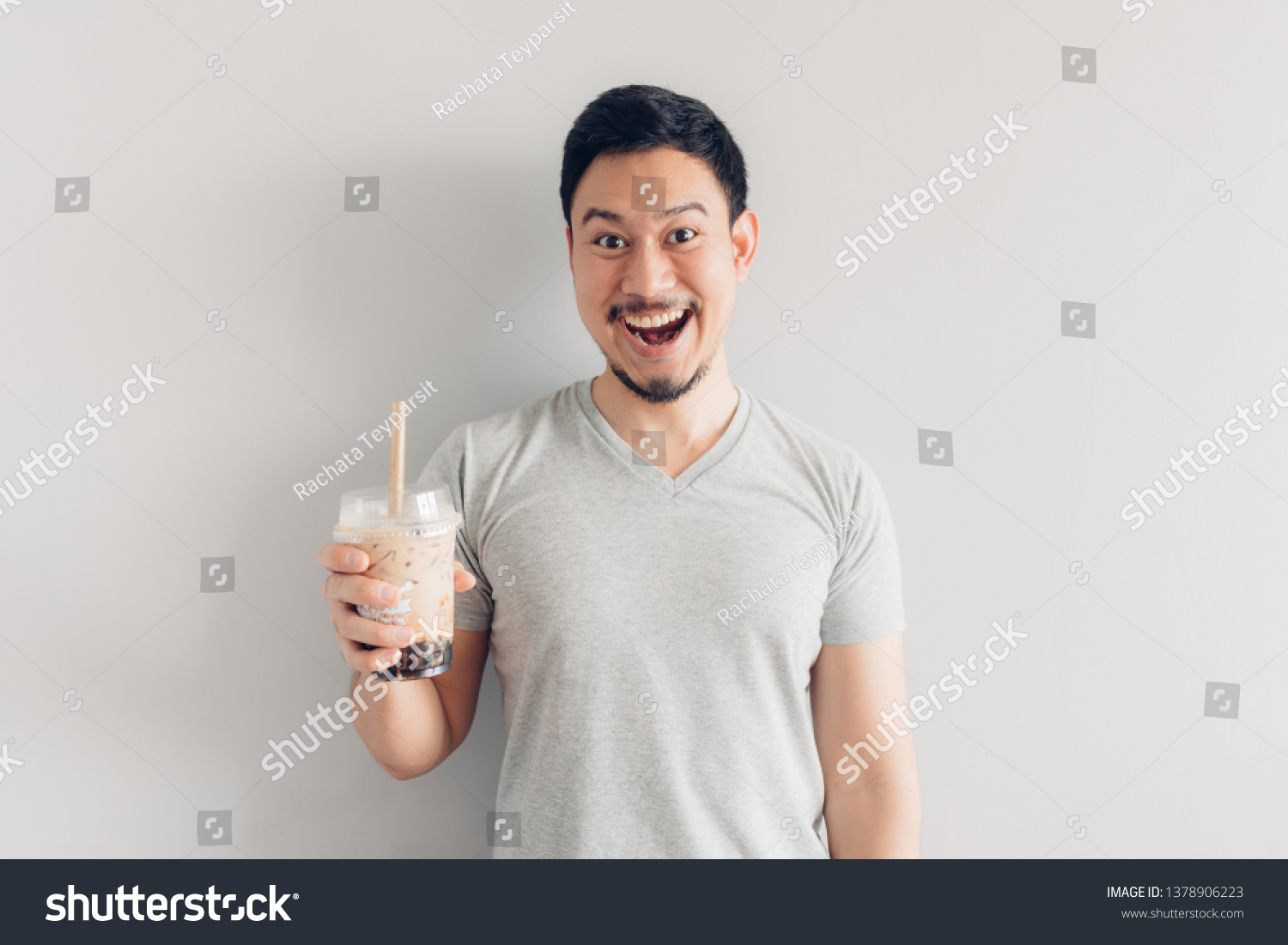 Happy Asian man is drinking Bubble Milk Tea or Pearl Milk Tea. Popular Milk Tea in Asia and Taiwan. #1378906223
