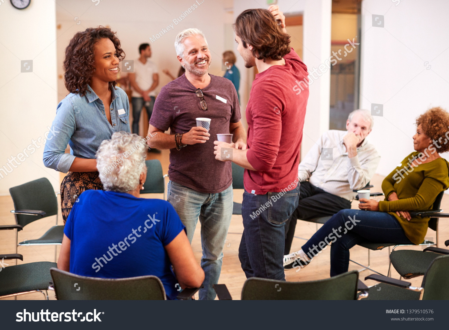 Group Of People Socializing After Meeting In Community Center #1379510576