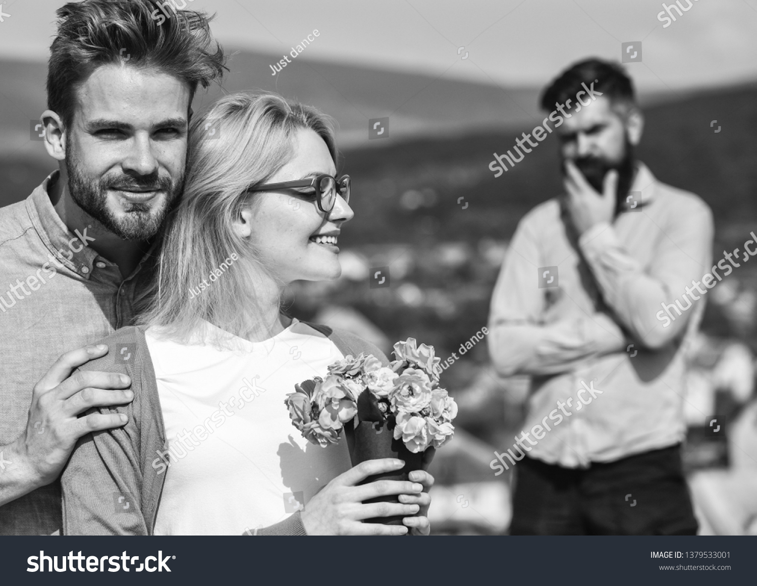 Lovers hugs outdoor flirt romance relations. Couple romantic date lovers bouquet flowers. Couple in love dating while jealous bearded man watching wife cheating him with lover. Infidelity concept. #1379533001
