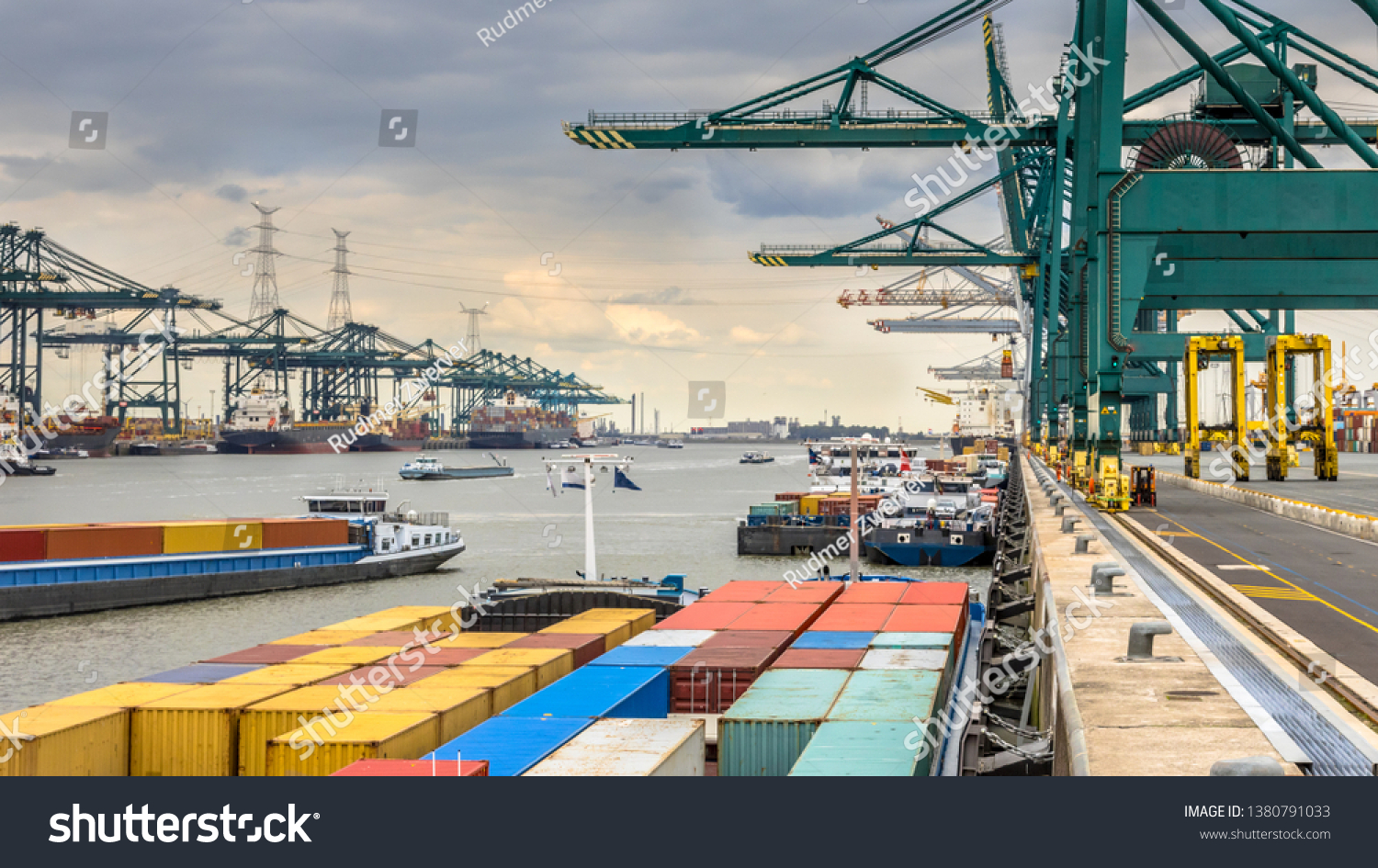 Loaded ships in busy port of Antwerp at container terminal with automated cranes and lots of vessels. Belgium #1380791033