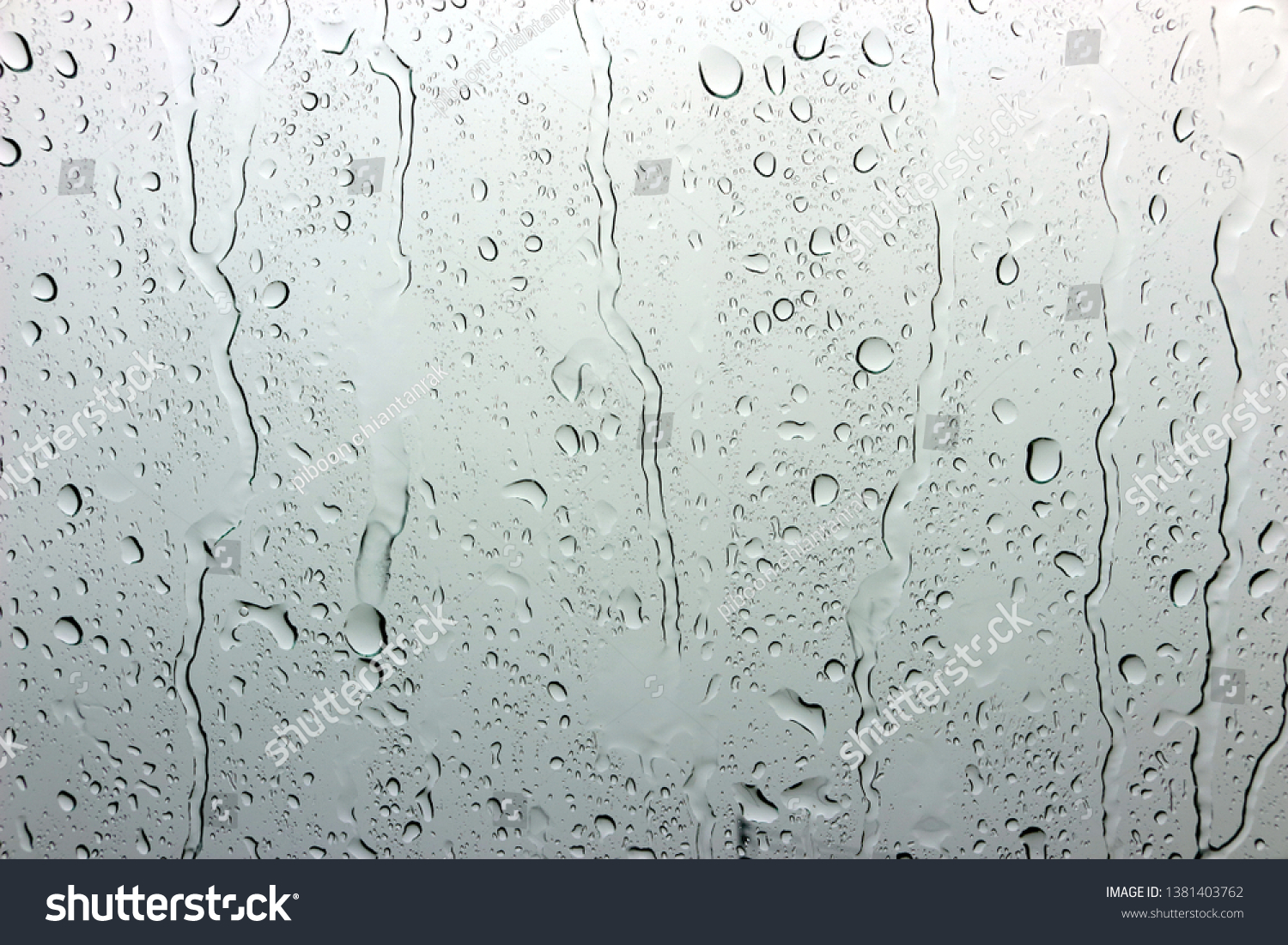 A small raindrop rests on the glass after rain. #1381403762