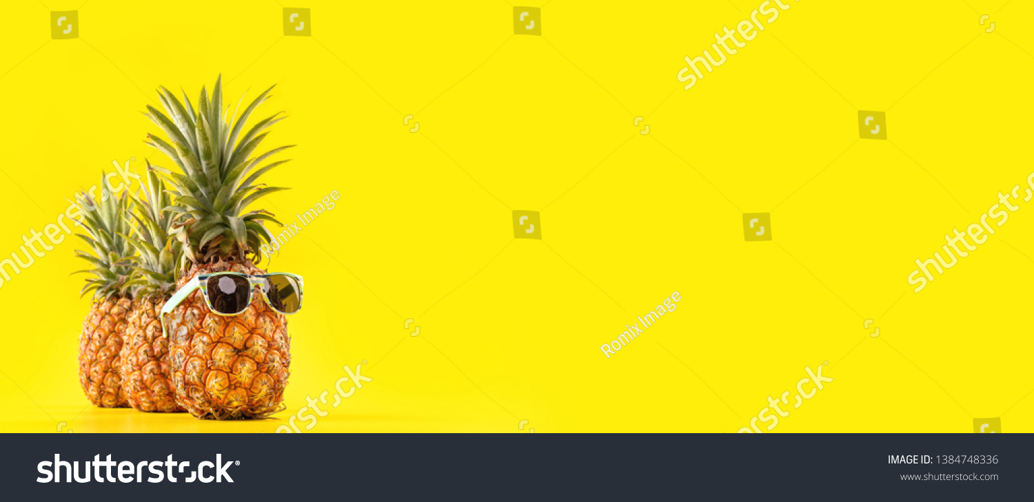 Creative pineapple looking up with sunglasses and shell isolated on yellow background, summer vacation beach idea design pattern, copy space close up #1384748336