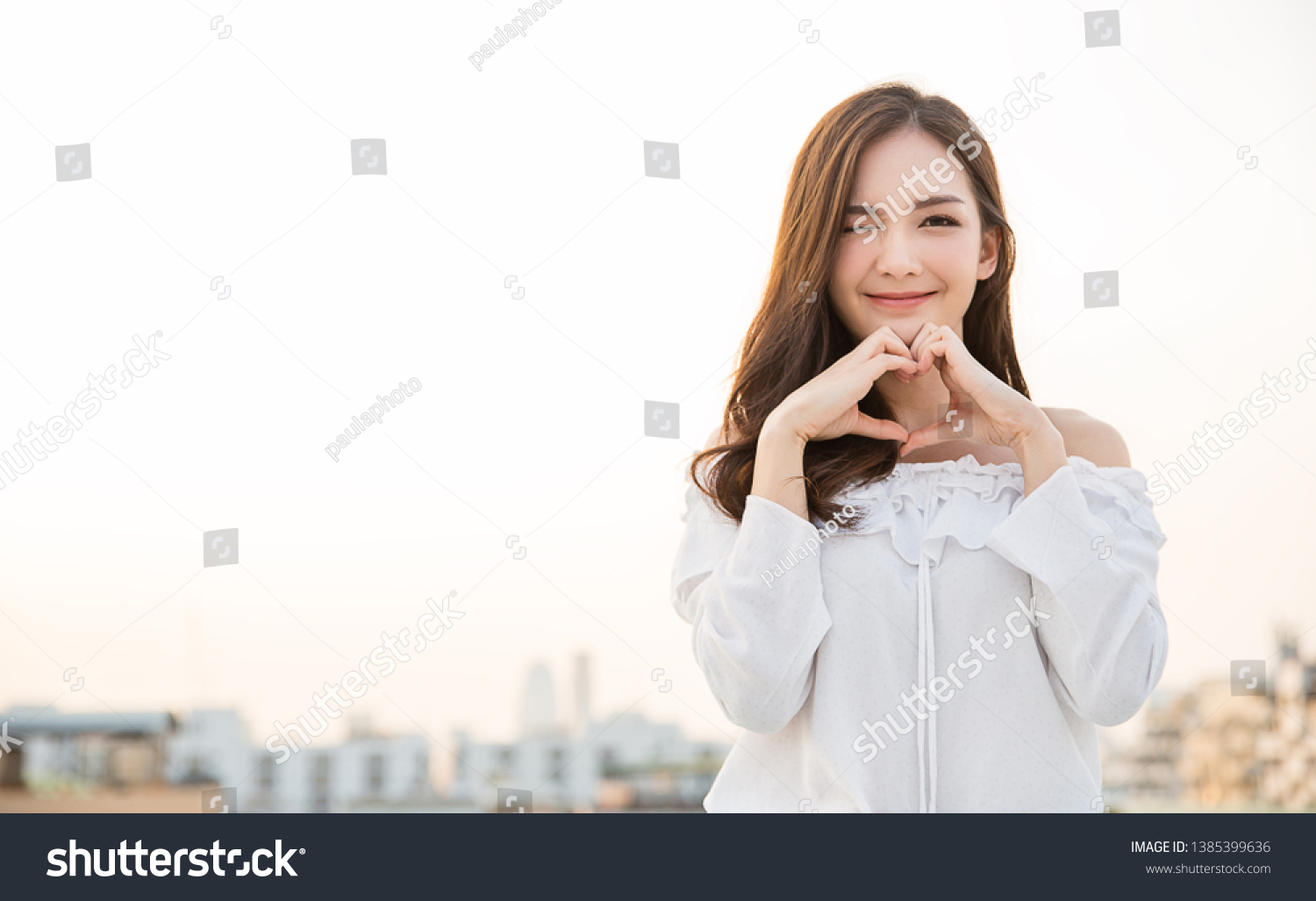 Portrait of young beautiful asian woman hands gesture in heart shape on city sky roof top. Smile face asian lady girl wear casual cloth. Japanese girl lifestyle, lovely woman valentines’ day concept  #1385399636