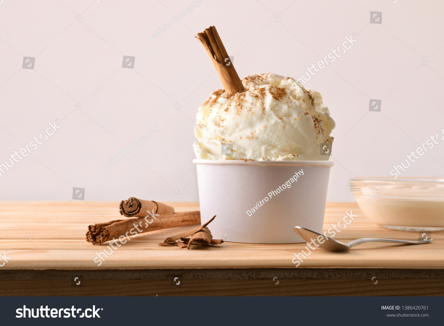 Cinnamon ice cream decorated with cinnamon sticks on a wooden table. Horizontal composition. Front view. #1386420761