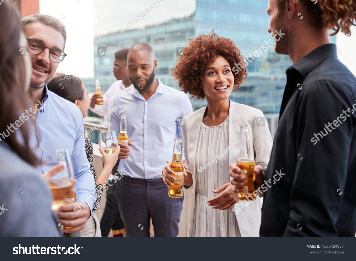 Office colleagues socialising with drinks in the city after work #1386424997
