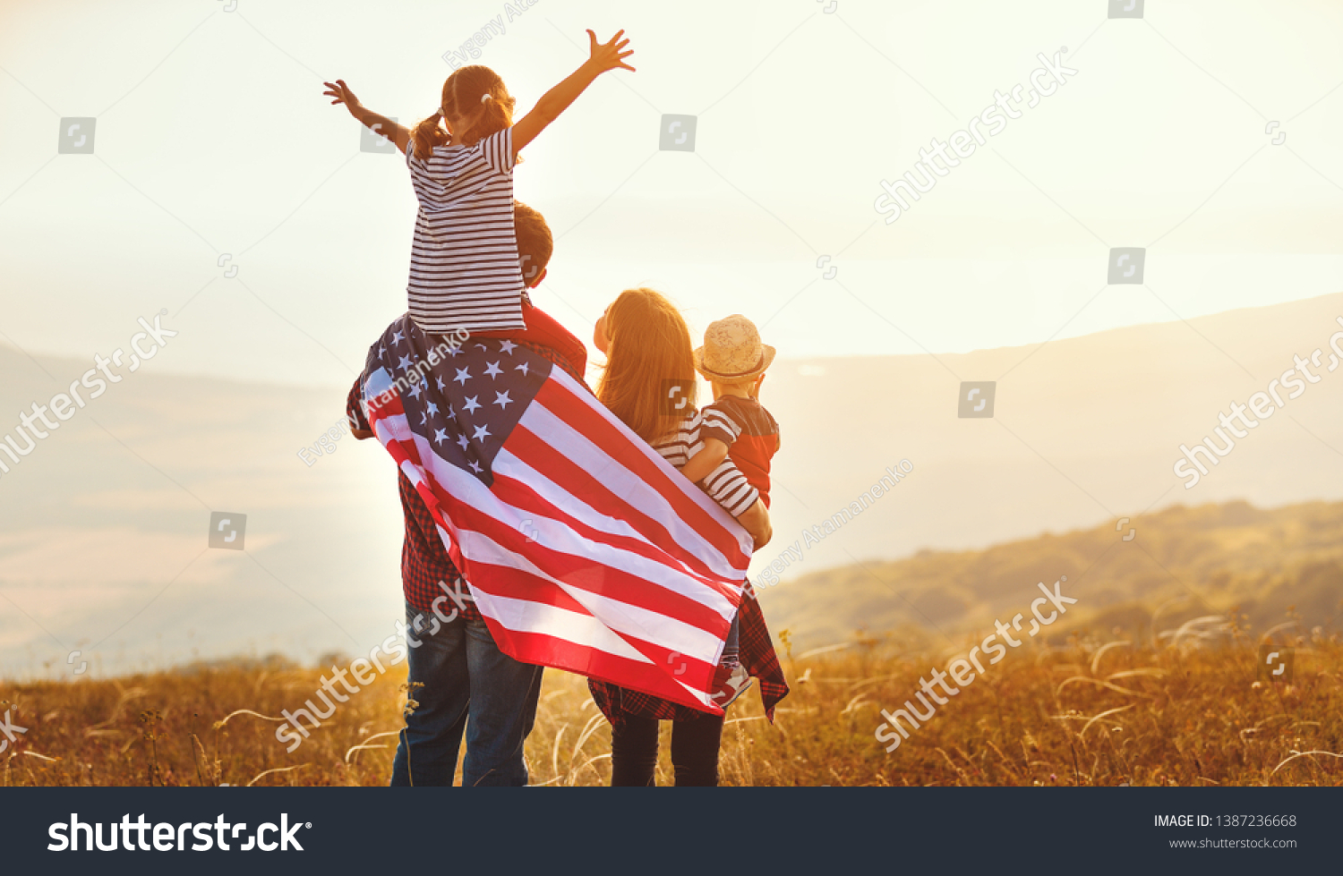 happy family with the flag of america USA at sunset outdoors
 #1387236668