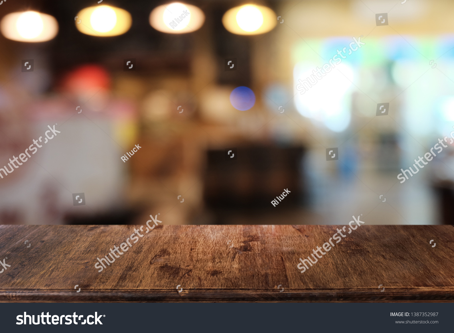 Empty dark wooden table in front of abstract blurred bokeh background of restaurant . can be used for display or montage your products.Mock up for space. #1387352987