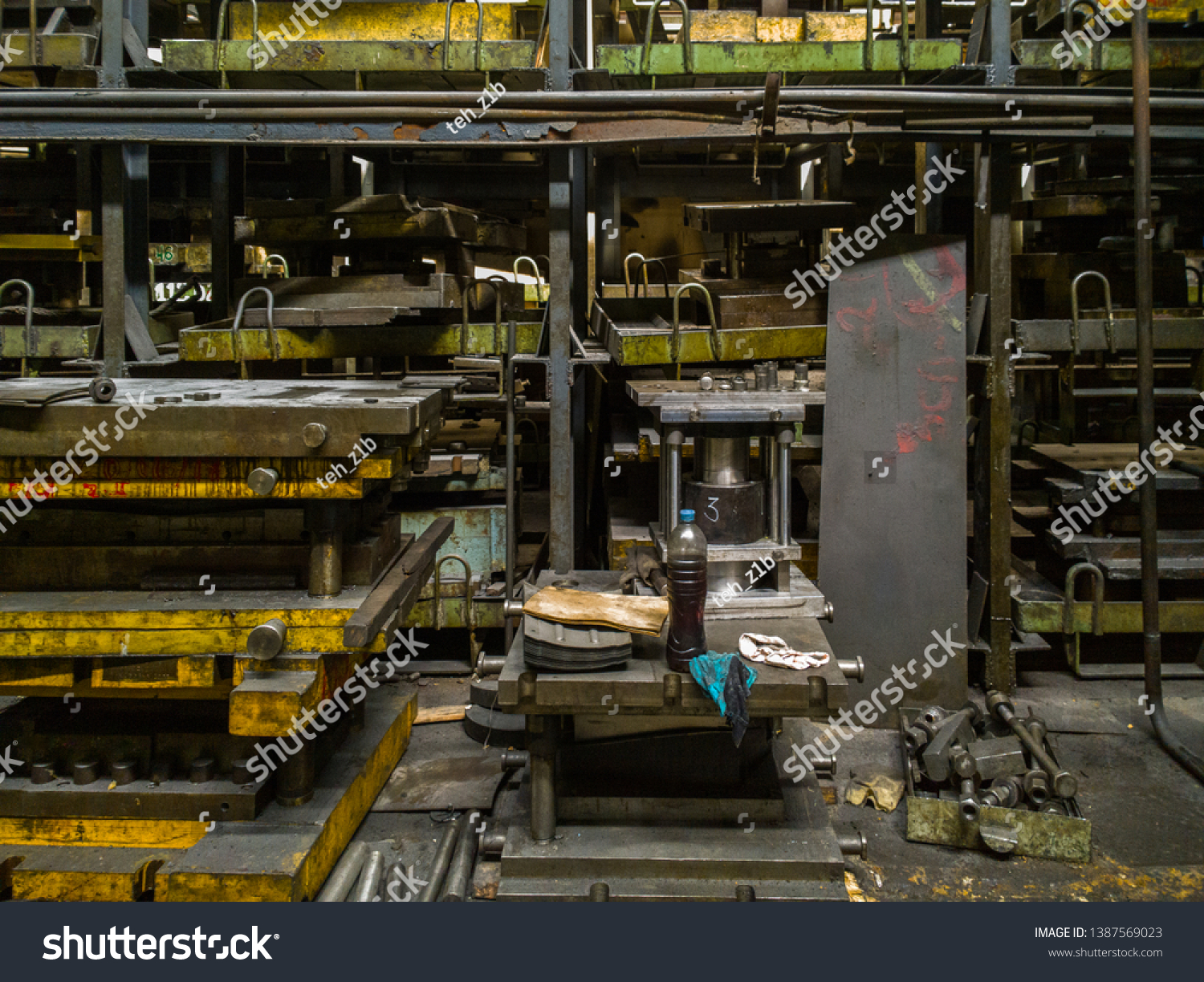 messy stamping shop with large stamps rack inside metalworking factory #1387569023