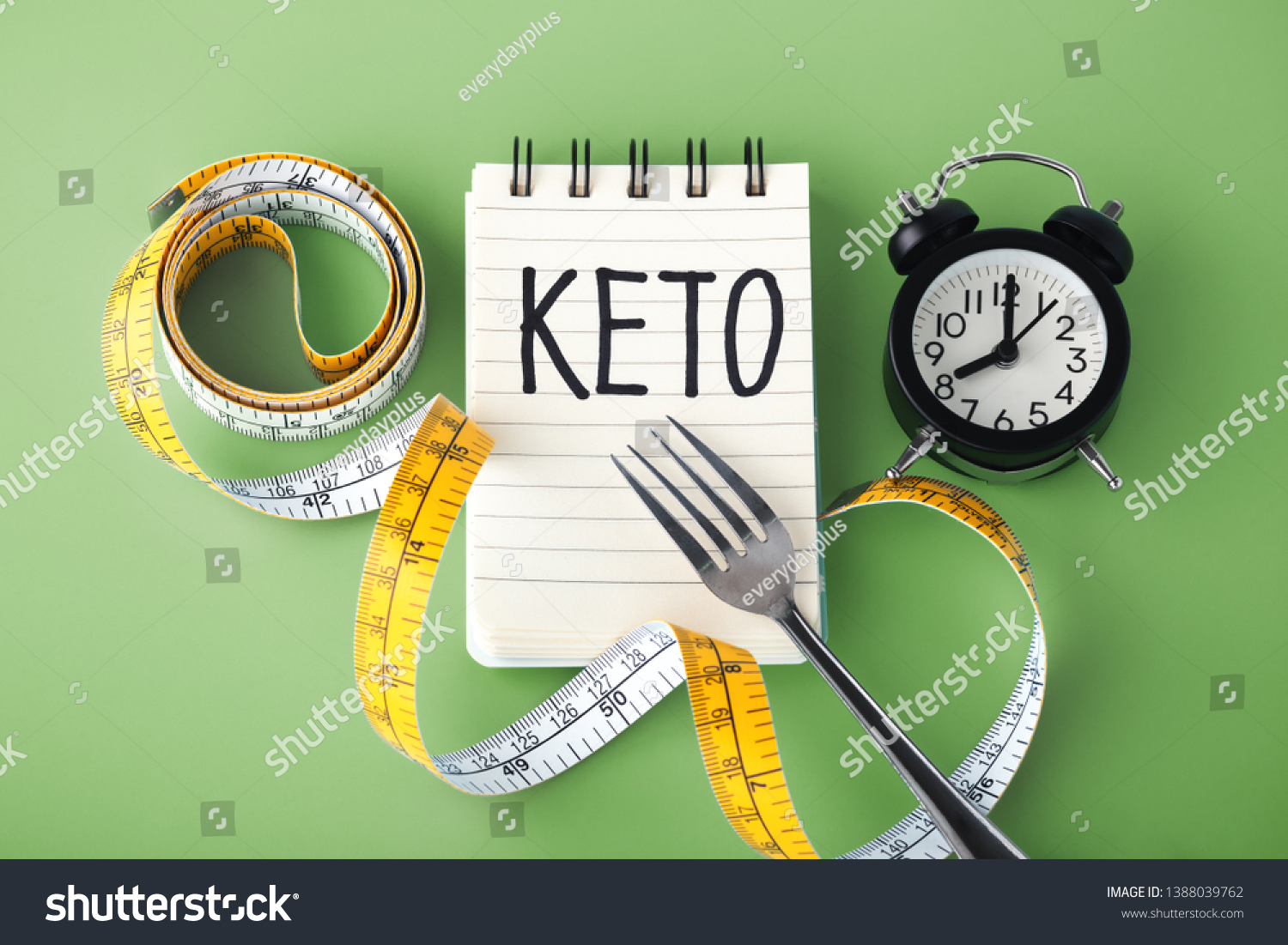 Keto word on notebook with clock fork and measuring tape around, intermittent fasting on keto concept #1388039762