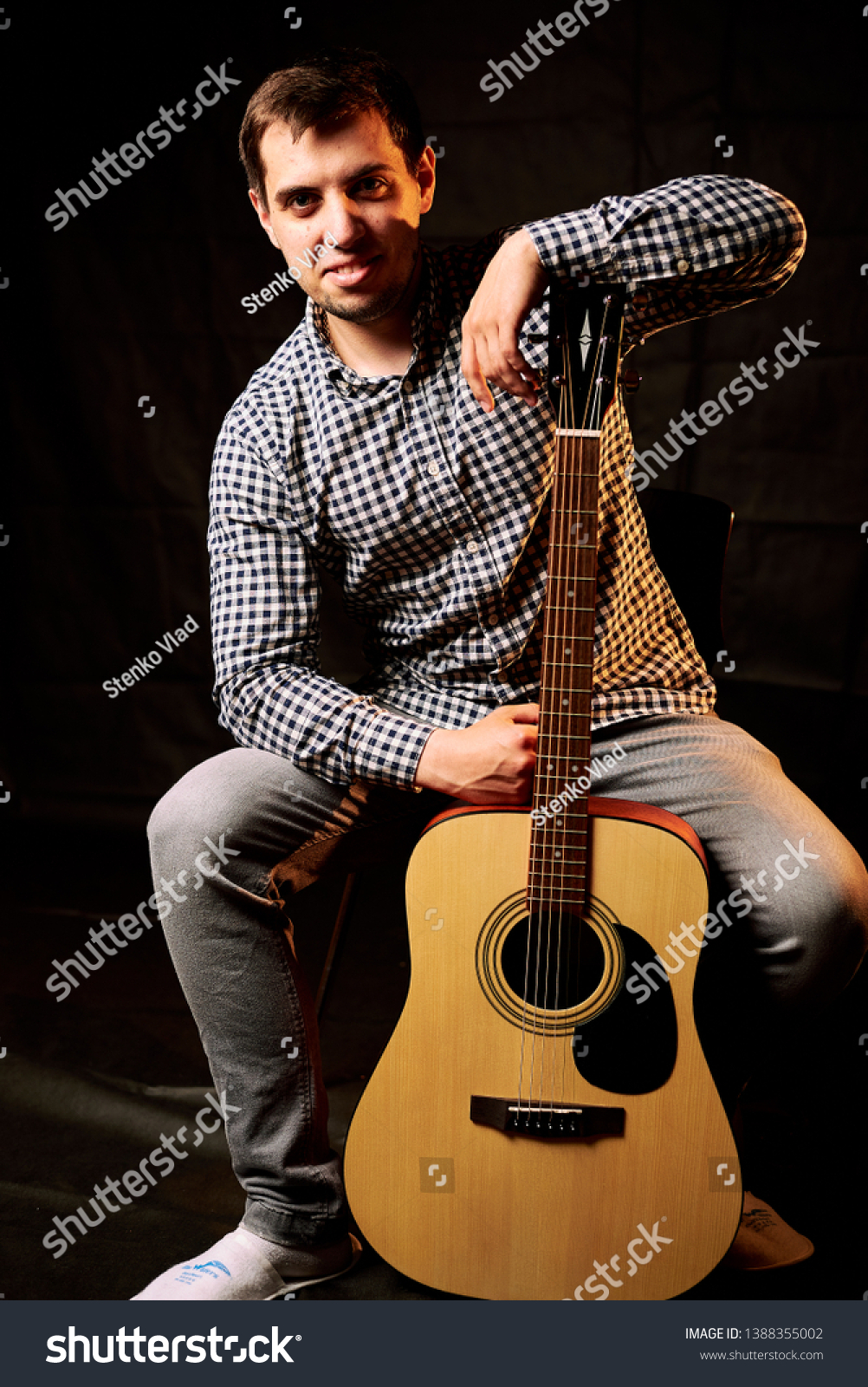 Young man playing acoustic guitar on grey background #1388355002