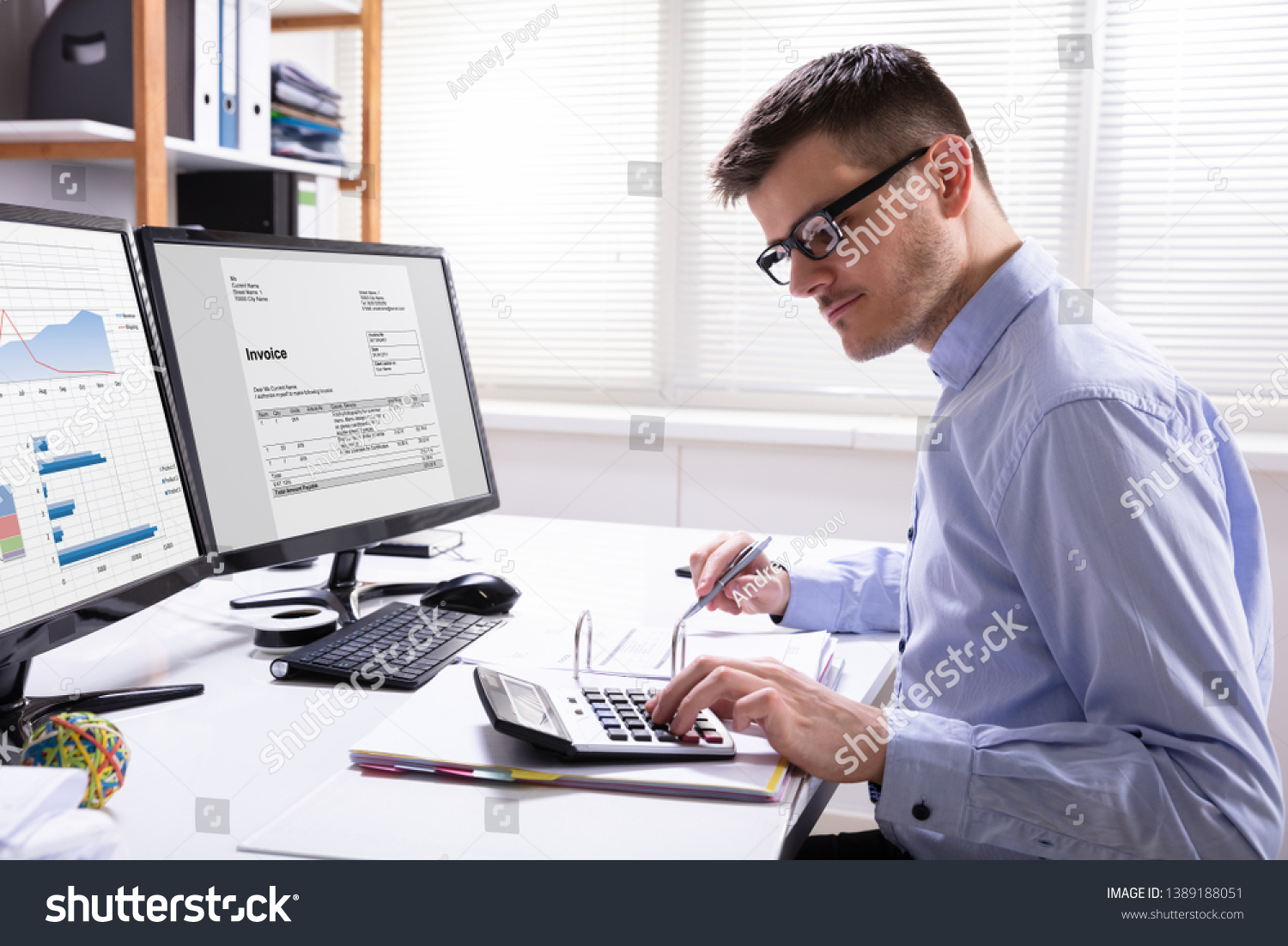 Side View Of Businessman's Hand Calculating Invoice At Workplace #1389188051