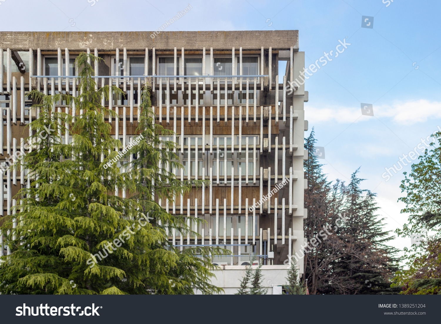 Close-up horizontal shoot of horizontal modern design concrete shading elements with trees #1389251204